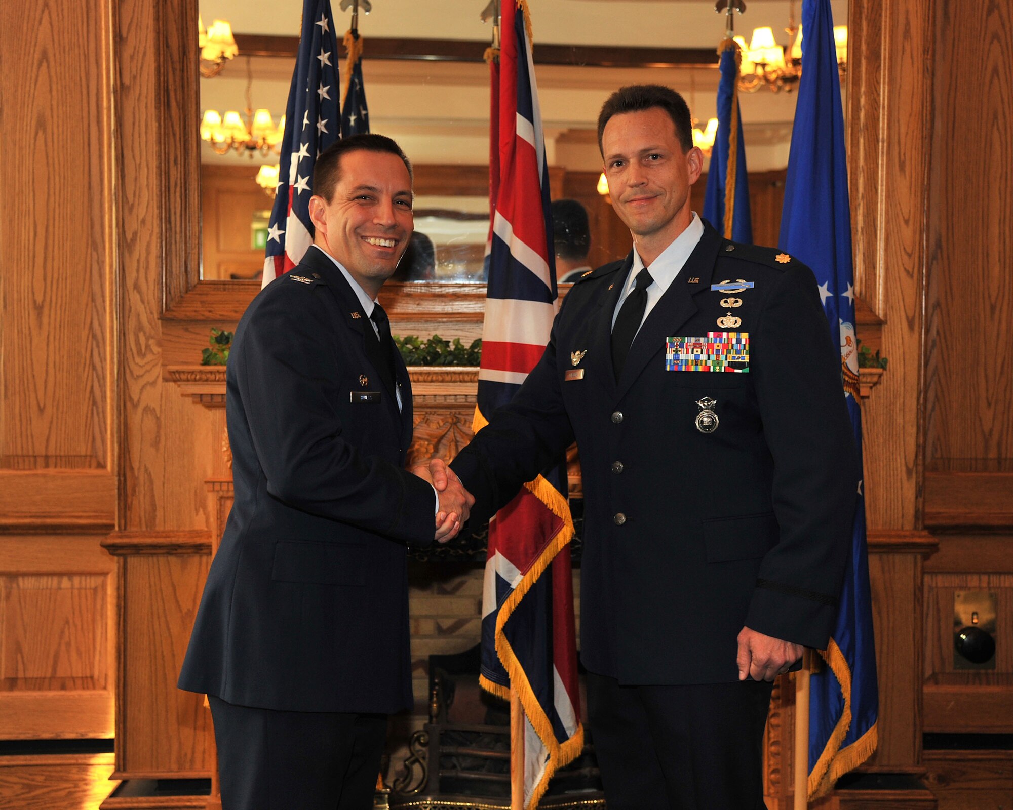 U.S. Air Force Maj. Matthew Gibson shakes hands with Col. Christopher Kulas, the commander of the 100th Air Refueling Wing, after receiving a British-American Council’s community relations award Sept. 24, 2011, at RAF Mildenhall, England. (U.S. Air Force photo by SrA Jerilyn Quintanilla) 