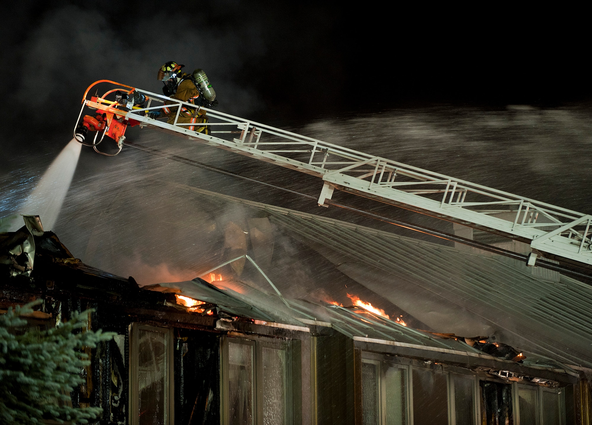 A Joint Base Elmendorf-Richardson firefighter battles a fire at building 9386 on JBER October 13, 2011. All occupants of the lodging facility were accounted for and no injuries were reported. (U.S. Air Force photo/Staff Sgt. Zachary Wolf)(Released)