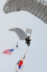 Parachuters from the Republic of Korea Air Force and U.S. Air Force float to the drop zone carrying their respective country flags during their jump from a C-130H Hercules out of Yokota Air Base, Japan, at the 2011 Gunsan-Saemangeum Airshow in Gunsan City, Republic of Korea, Oct. 9, 2011. The U.S. Air Force and ROKAF performed the jump together at 10,000 feet from a C-130, highlighting military free-fall operations during the air show. The City of Gunsan, the 8th Fighter Wing and the Republic of Korea Air Force’s 38th Fighter Group hosted the air show. (U.S. Army photo by Spc. Christopher Wellner/Released)