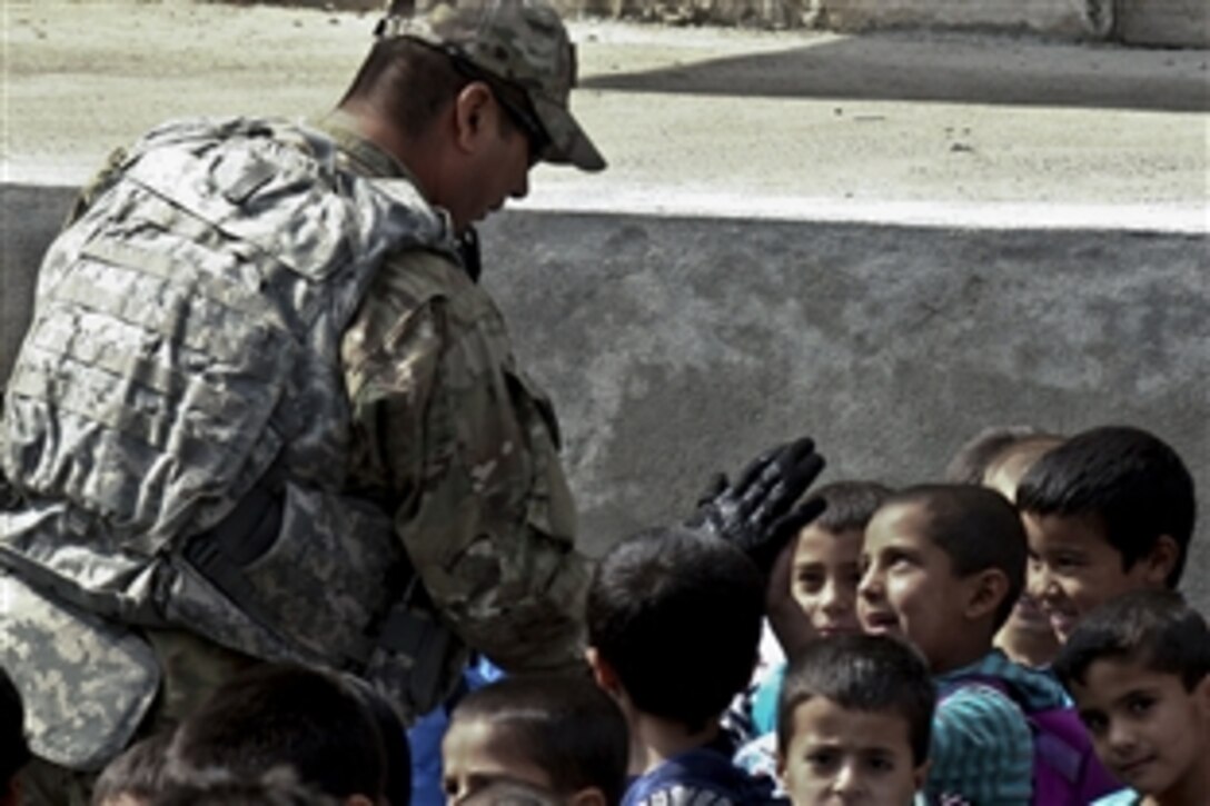 U.S. Air Force Capt. Daniel Vargas high fives with a student at Jawid High School in Kabul, Afghanistan, Oct. 12, 2011. His visit was part of a mission to provide school supplies to school children. U.S. troops distributed more than 200 bags of supplies donated by family members and aid organizations in the United States. 