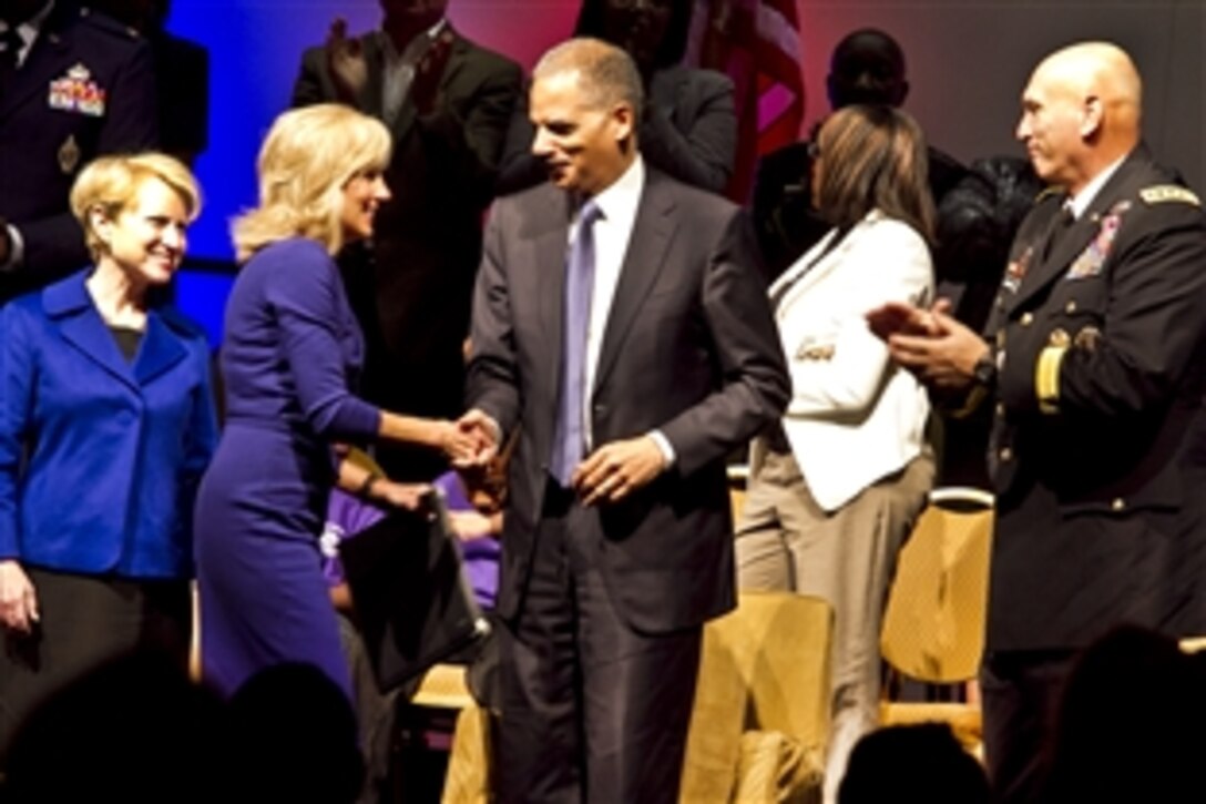 Dr. Jill Biden, wife of Vice President Joe Biden, shakes hands with Attorney General Eric Holder while Army Chief of Staff Gen. Raymond T. Odierno looks on after each addressed the audience at the Office of Juvenile Justice and Delinquency Prevention Naitonal Conference at National Harbor, Md., Oct. 14, 2011. Biden and Odierno spoke to child support professionals on behalf of military children, citing the challenges and stresses they endure.