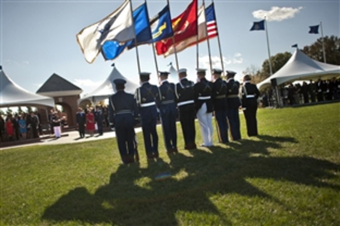 The Honor Guard holds the colors while Defense Secretary Leon E. Panetta awards Linda McNabb, wife of Air Force Gen. Duncan J. McNabb, the Defense Distinguished Public Service Award during the U.S. Transportation Command change-of-command ceremony, where Air Force Gen. William M. Fraser III assumed leadership of the command from Gen. McNabb on Scott Air Force Base, Ill., Oct. 14, 2011.