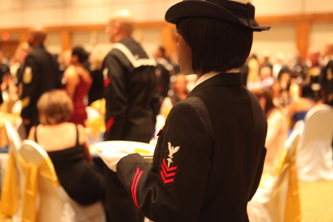 A member of the ceremony carries a slice of lemon to the Prisoner of War table during the 236th Navy Birthday Ball at the New Bern Convention Center, New Bern, N.C., Oct. 15. The lemon wedge symbolizes the POW’s bitter fate, if they do not make it home safely.