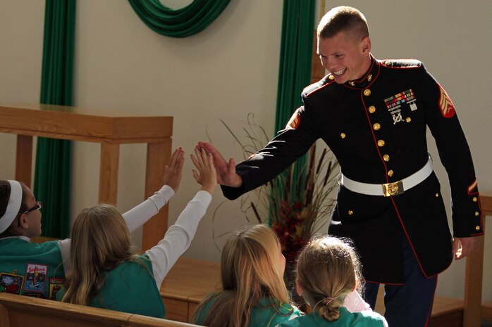 Sgt. Dustin M. Ardolf, 25, from Chisago City, Minn., high fives a group of Girl Scouts before delivering a presentation about the Marine Corps at Cross of Peace Lutheran Church Oct. 15. During his presentation, Ardolf discussed military customs and courtesies, historical facts and gear currently being used in Iraq and Afghanistan. The ladies who attended the event will earn the "US Marine Pride" merit badge. Ardolf is a 2004 graduate from Chisago Lakes High School and a recruiter out of the Burnsville, Minn., office. For additional imagery from the event, visit www.facebook.com/rstwincities.