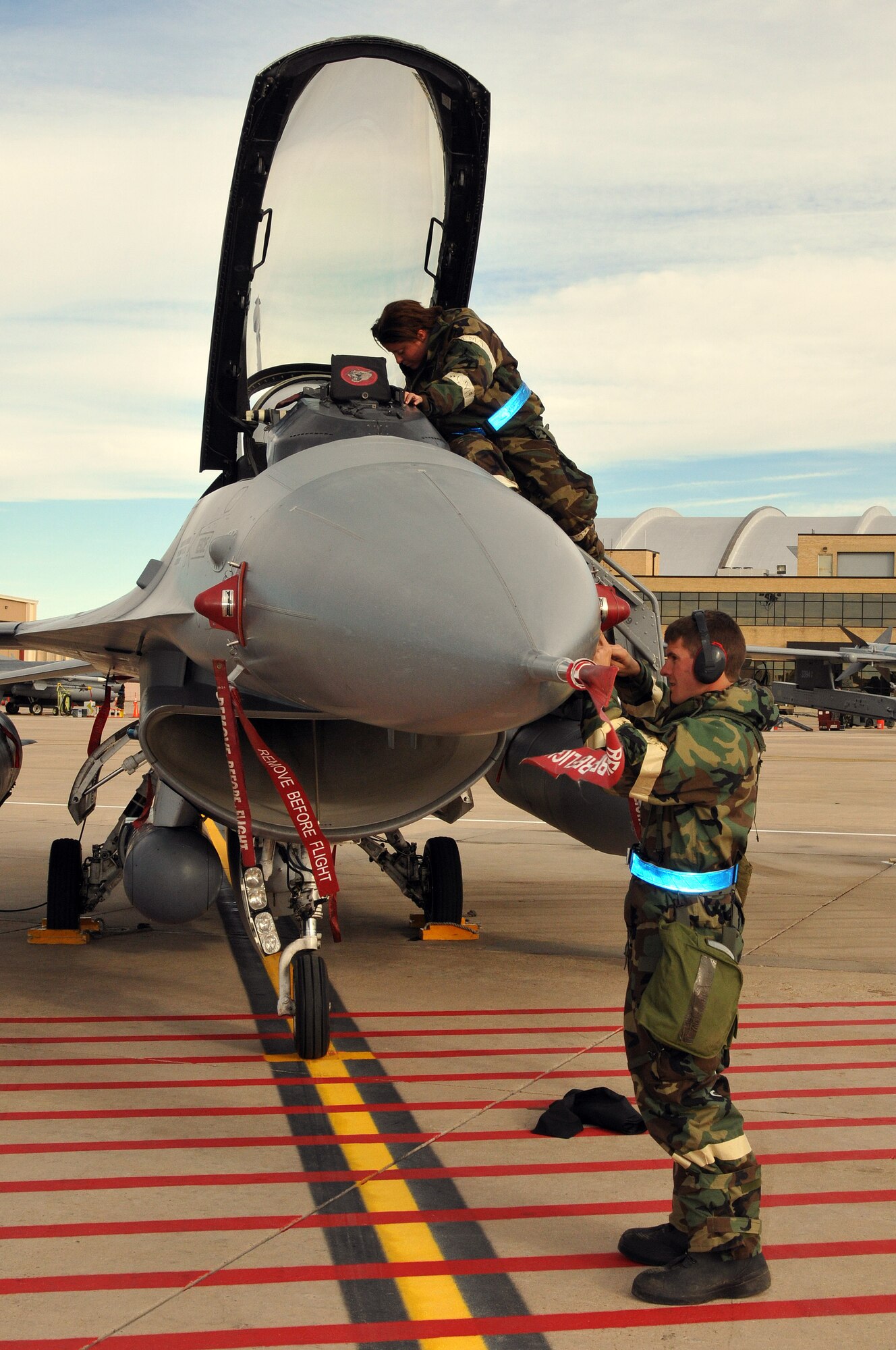 U.S. Air Force Airman First Class Ryan Eisencach and Airman First Class Dusty Alynn, 140th Aircraft Maintenance Squadron, cover vital instruments and sensors on an F-16 Fighting Falcon after a resent flight during an Operational Readiness Exercise at Buckley Air Force Base Colo., October 15, 2011. Buckley Air National Guard airmen are taking part in the Operational Readiness Exercise being held on base throughout the weekend. The ORE evaluates airmen with mission readiness in preparation for real world deployments as well as next year’s Operational Readiness Inspection.  U.S. Air Force photo by: Wolfram M. Stumpf (RELEASED)