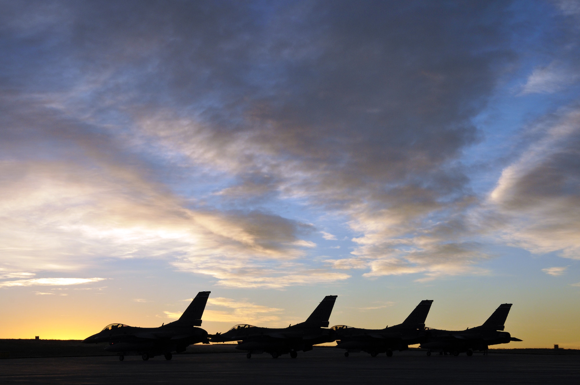 Four F-16 Fighting Falcons from the 120th Fight Squadron, wait for their final checks to be completed before an early morning takeoff during an Operational Readiness Exercise at Buckley Air Force Base Colo., October 15, 2011. Buckley Air National Guard airmen are taking part in the Operational Readiness Exercise being held on base throughout the weekend. The ORE evaluates airmen with mission readiness in preparation for real world deployments as well as next year’s Operational Readiness Inspection.  U.S. Air Force photo by: Wolfram M. Stumpf (RELEASED)
