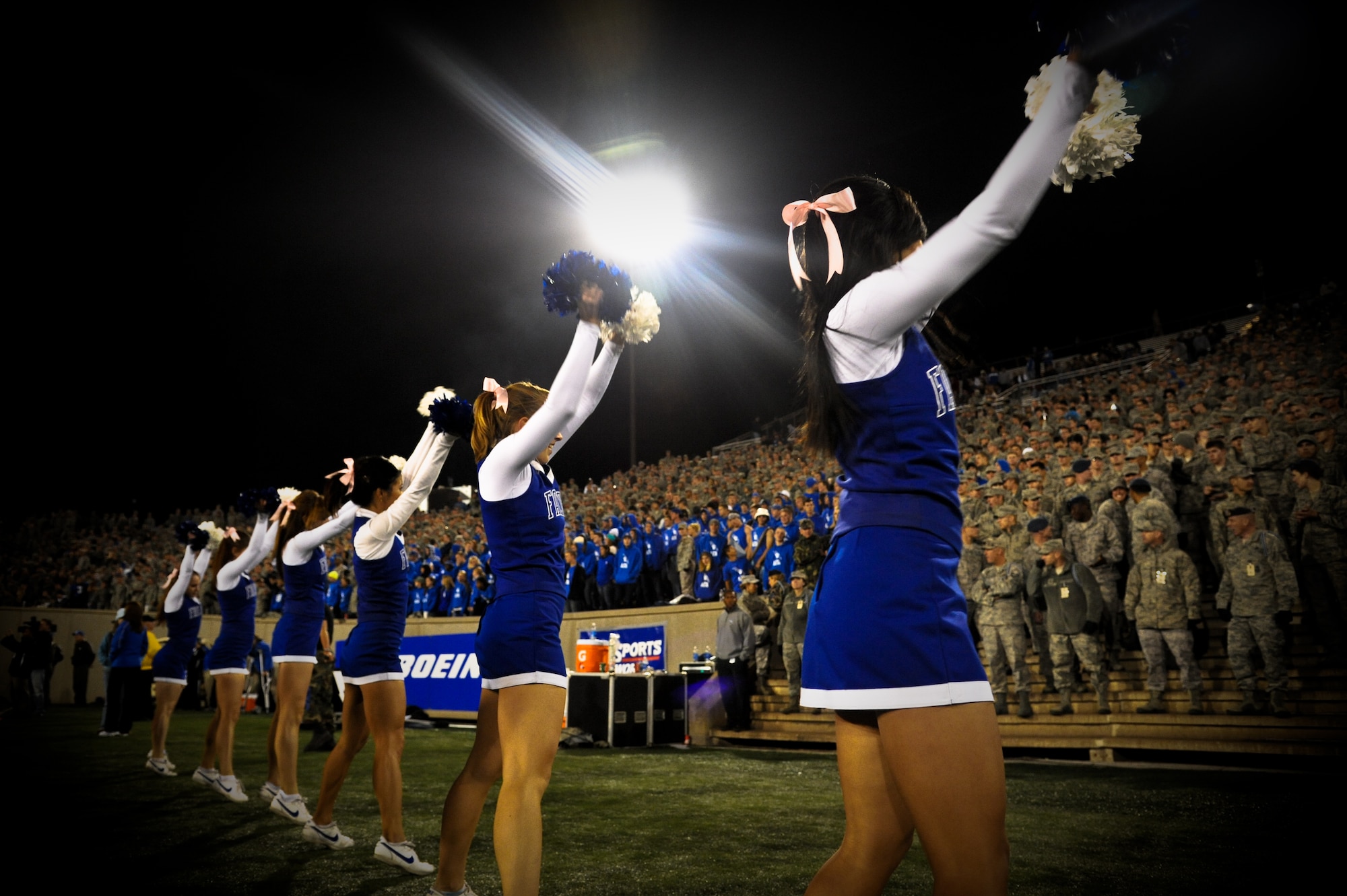 U.S. Air Force Academy cheerleaders urge the crowd to sing along as they cheer on the USAFA Falcons during a homegame in Colorado Springs, Co., Oct. 13. While the Falcons didn't win, they didn't let the loss dent their pride. At the end of the game, fans and cadets alike gathered on the field to sing the Air Force song. (U.S. Air Force Photo/Senior Airman Lauren Main)