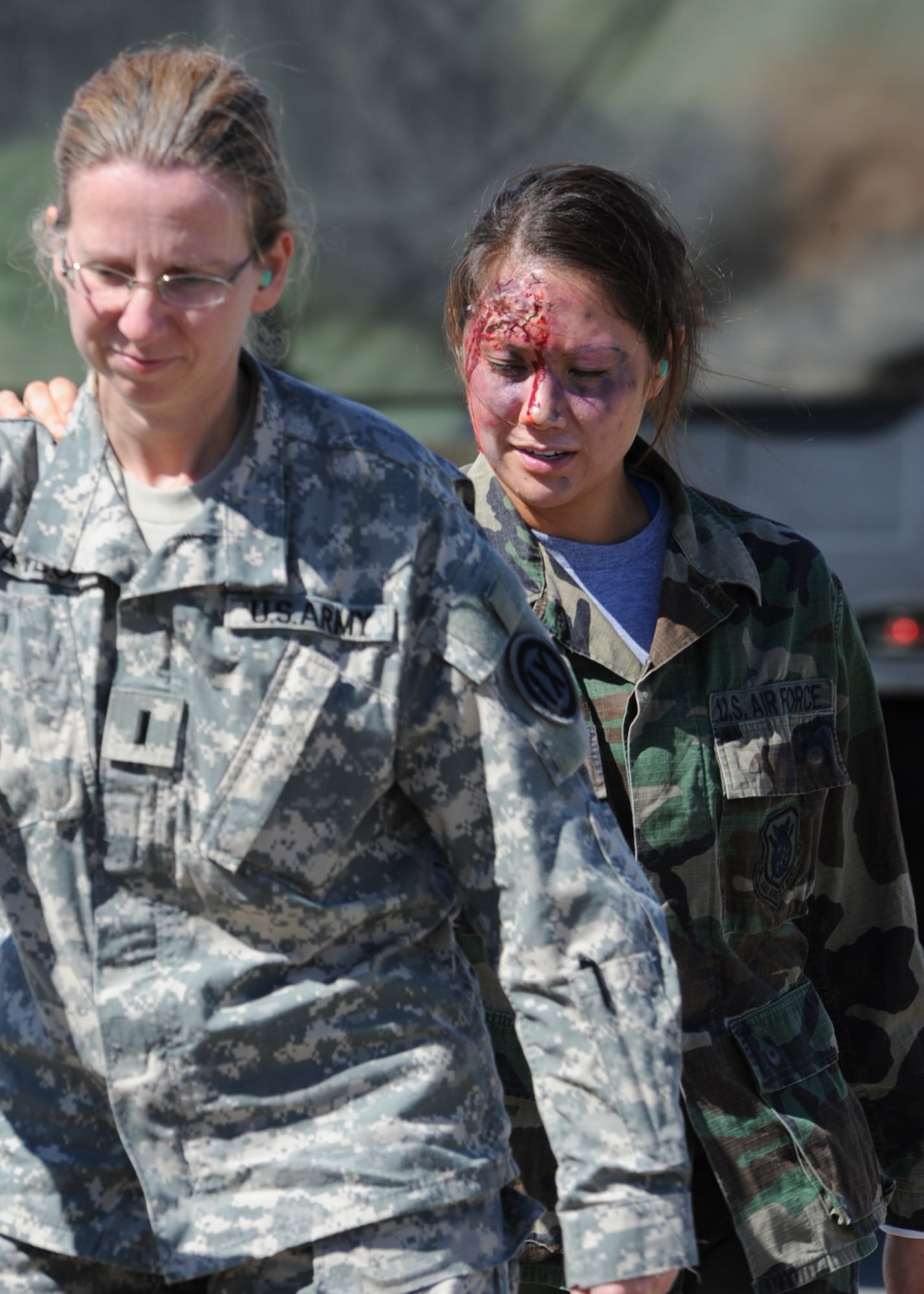 An Injured Airman with the 440th Airlift Wing follows an injured Soldier during escort to an awaiting C-130 Hercules aircraft during a joint-force mass casualty medical evacuation training exercise at Fort Bragg, N.C., on Oct. 15, 2011.  The exercise was geared toward building communication and shared leadership responsibilities between the Army and Air Force medical staffs at Fort Bragg and Pope Field, N.C.  It combined simulated injuries and scenarios with real-world assets to replicate in-theater operational conditions.  (U.S. Air Force photo by Staff Sgt. Peter R. Miller)