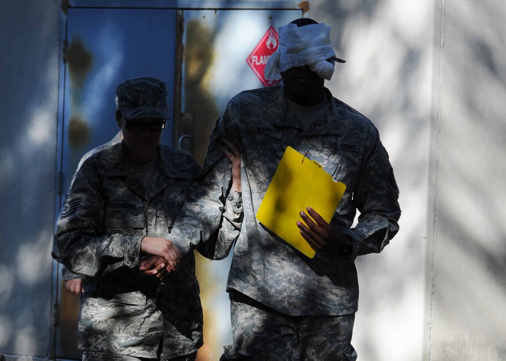 Technical Sergeant Carrie Caccione, a medical technician with the 440th Airlift Wing Medical Squadron, escorts a sightless Soldier, U.S. Army Nurse 1st Lieutenant Sergio Ward with the 3274th U.S. Army Hospital, during a joint-force mass casualty medical evacuation training exercise at Pope Field, N.C., on Oct. 15, 2011.  The exercise was geared toward building communication and shared leadership responsibilities between the Army and Air Force medical staffs at Fort Bragg and Pope Field, N.C.  It combined simulated injuries and scenarios with real-world assets to replicate in-theater operational conditions.  (U.S. Air Force photo by Staff Sgt. Peter R. Miller) 