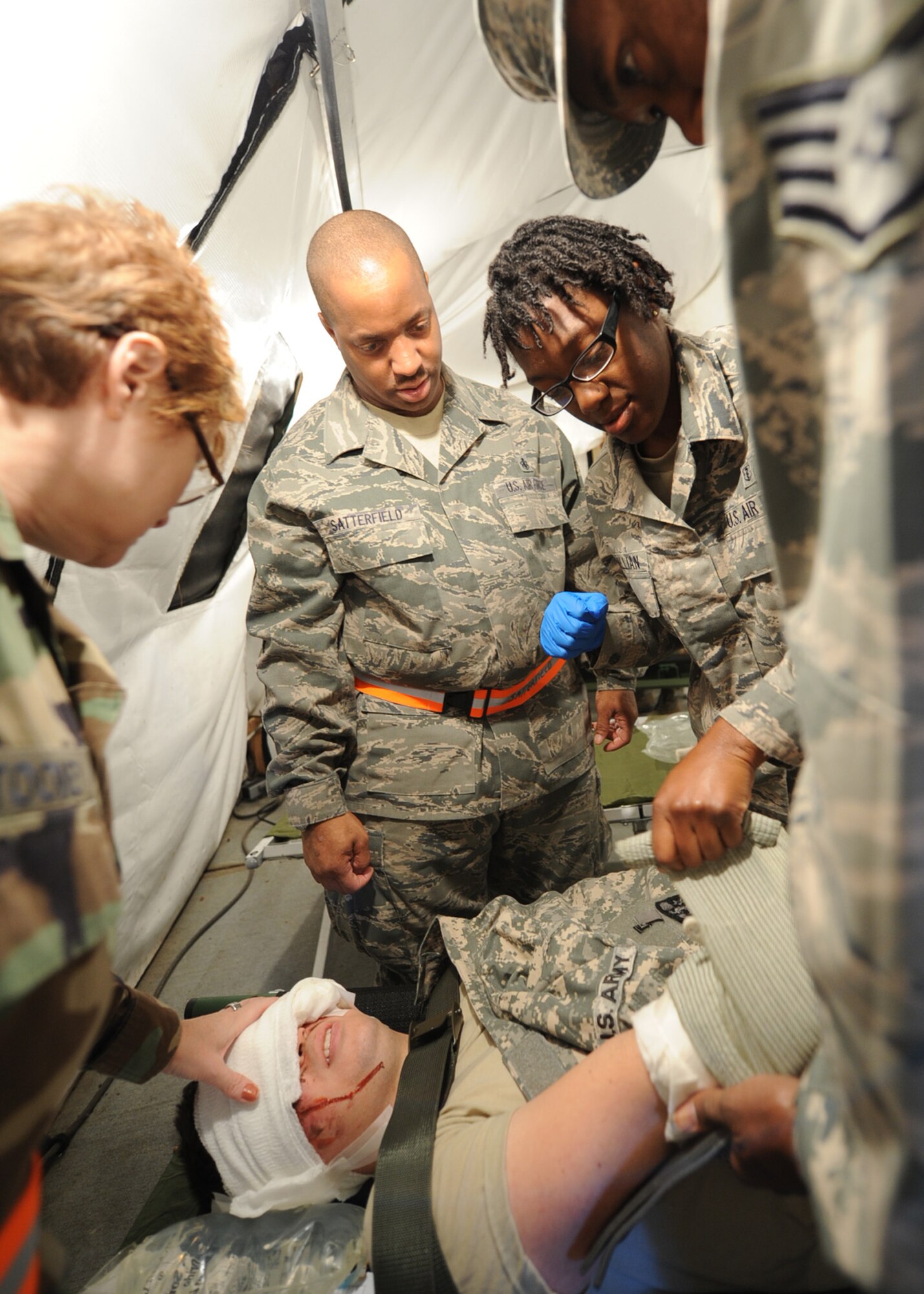 Medical personnel with the 440th Airlift Wing Medical Squadron provide life-saving care to an injured U.S. Army Soldier during a joint-force mass casualty medical evacuation training exercise at Fort Bragg, N.C., on Oct. 15, 2011.  The exercise was geared toward building communication and shared leadership responsibilities between the Army and Air Force medical staffs at Fort Bragg and Pope Field, N.C.  It combined simulated injuries and scenarios with real-world assets to replicate in-theater operational conditions.  (U.S. Air Force photo by Staff Sgt. Peter R. Miller) 