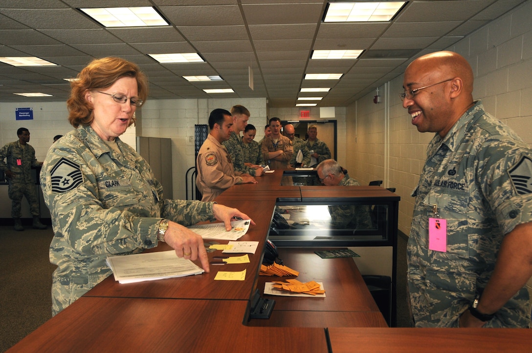 Senior Master Sgt. Susan Clark, 113th Logistics Readiness Squadron plans and integration superintendent, receives help from Master Sgt. Arthur Powell, 113th Force Support Squadron, during her outprocessing on Joint Base Andrews Oct. 7.  More than 175 113 WG members departed on the Air Expeditionary Force deployment.    (U.S. Air Force photo/Tech Sgt. Craig Clapper)  
