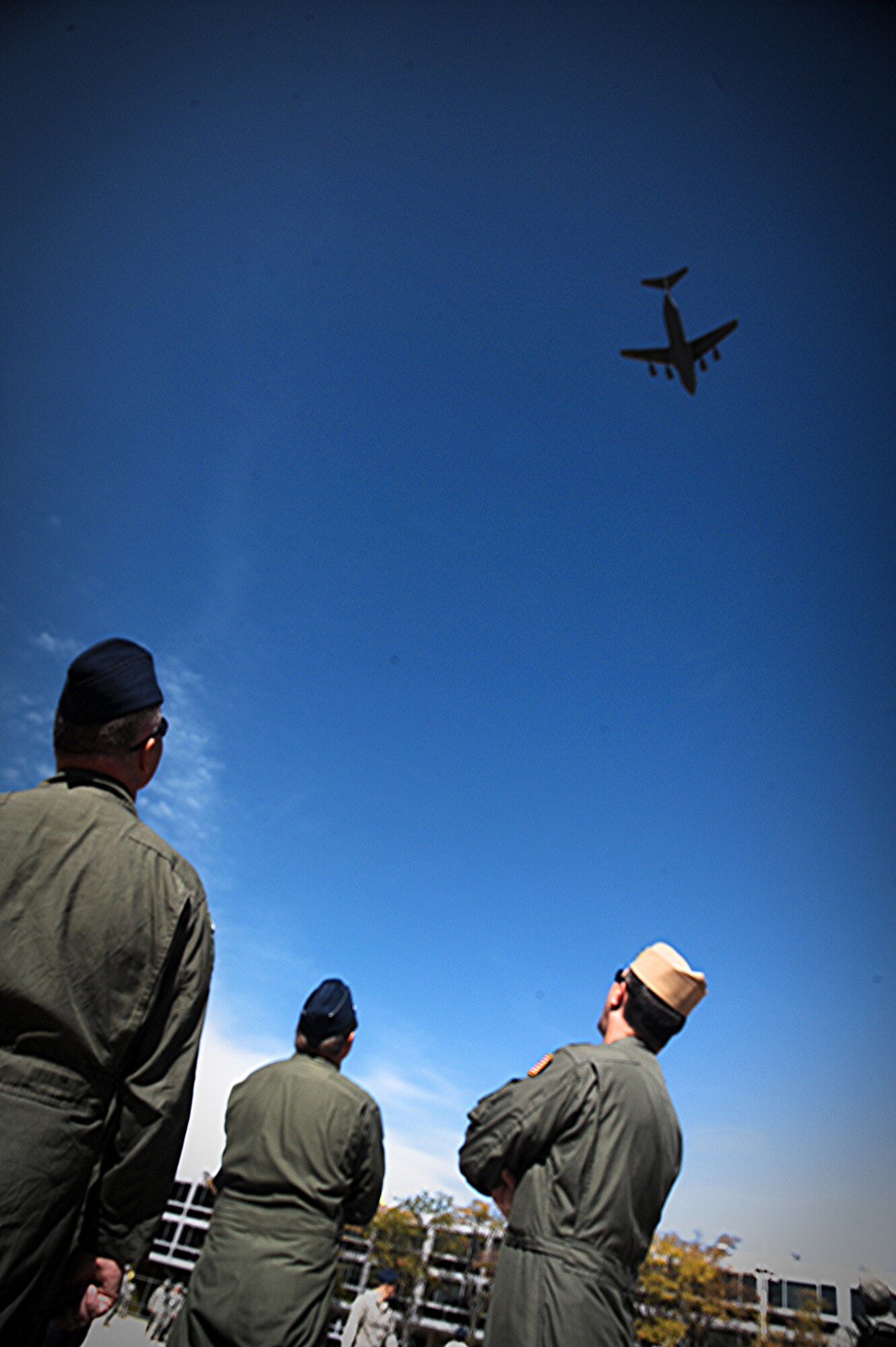 Instructors at the U.S. Air Force Academy, Colorado Springs, Co., watch as a C-17 Globemaster III, assigned to the 15th Wing, performs a flyover at the Academy on Oct. 12. The C-17 crew performed numerous training missions and flyovers during an off station training mission to USAFA, including a pass over the USAFA Falcons vs. San Diego State University football game Oct.13.  (U.S. Air Force photo/Senior Airman Lauren Main)