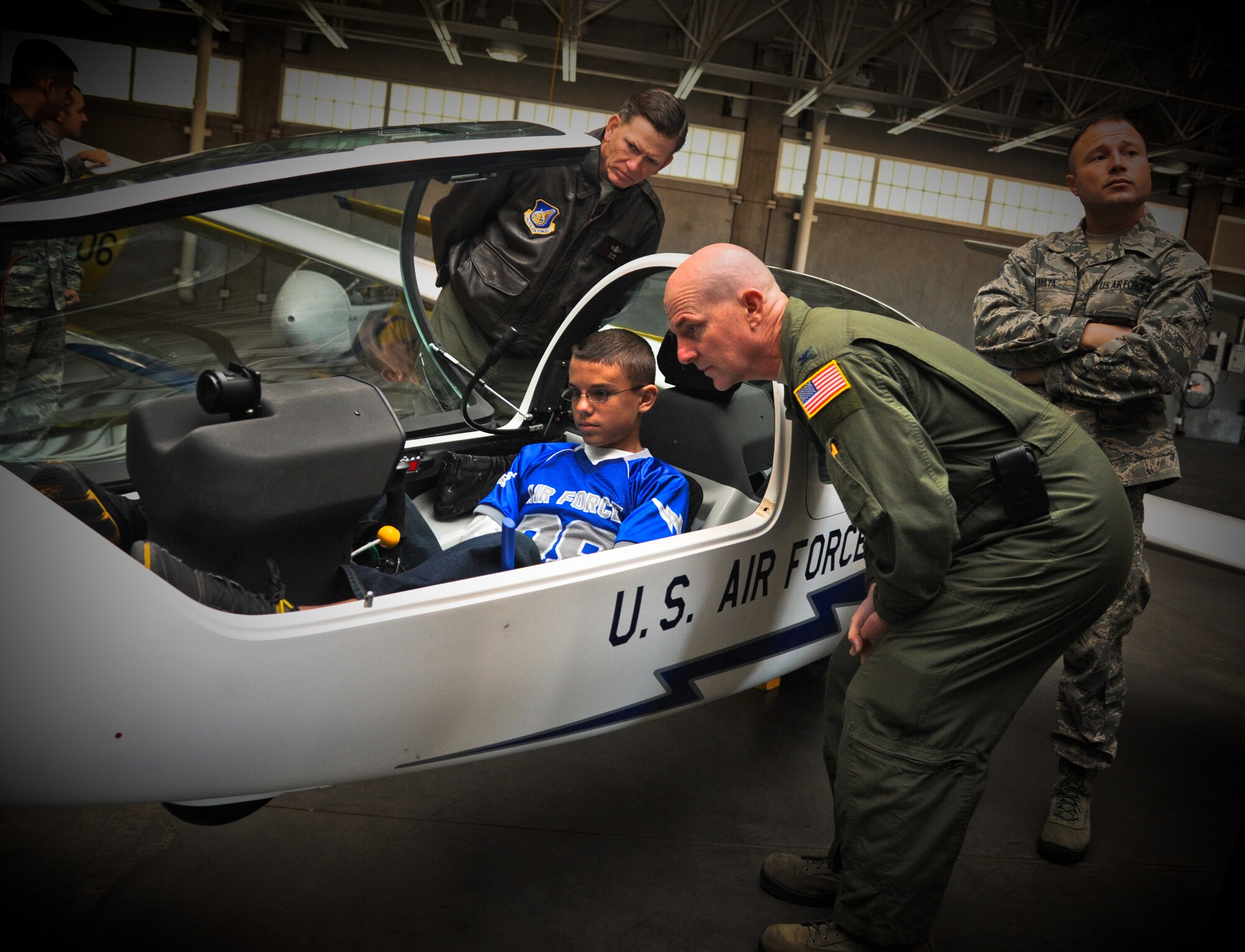 Col. Sam Barrett, 15th Wing commander, and Col. Joe Dague, 15th Wing vice commander, look over Sam Barrett Jr's shoulder as he examines the controls of a glider plane at the 306th Flying Training Group, U.S. Air Force Academy, Colorado Springs, Co., Oct. 12. The glider was one of many that the cadets can learn to pilot throughout their time at the Academy. (U.S. Air Force photo/Senior Airman Lauren Main)