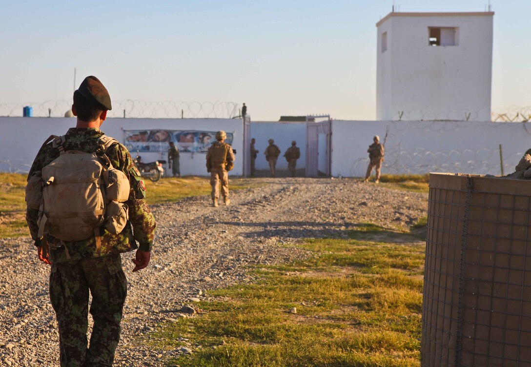 Afghan National Army soldiers with 1st Kandak, 1st Brigade, 215th Corps, and Marines with 1st Battalion, 9th Marine Regiment, enter Loy Kolay precinct, an ANA security outpost.  The precinct was a welcome sight to the security forces after a 14-kilometer patrol on the first of a four-day patrol through the district.