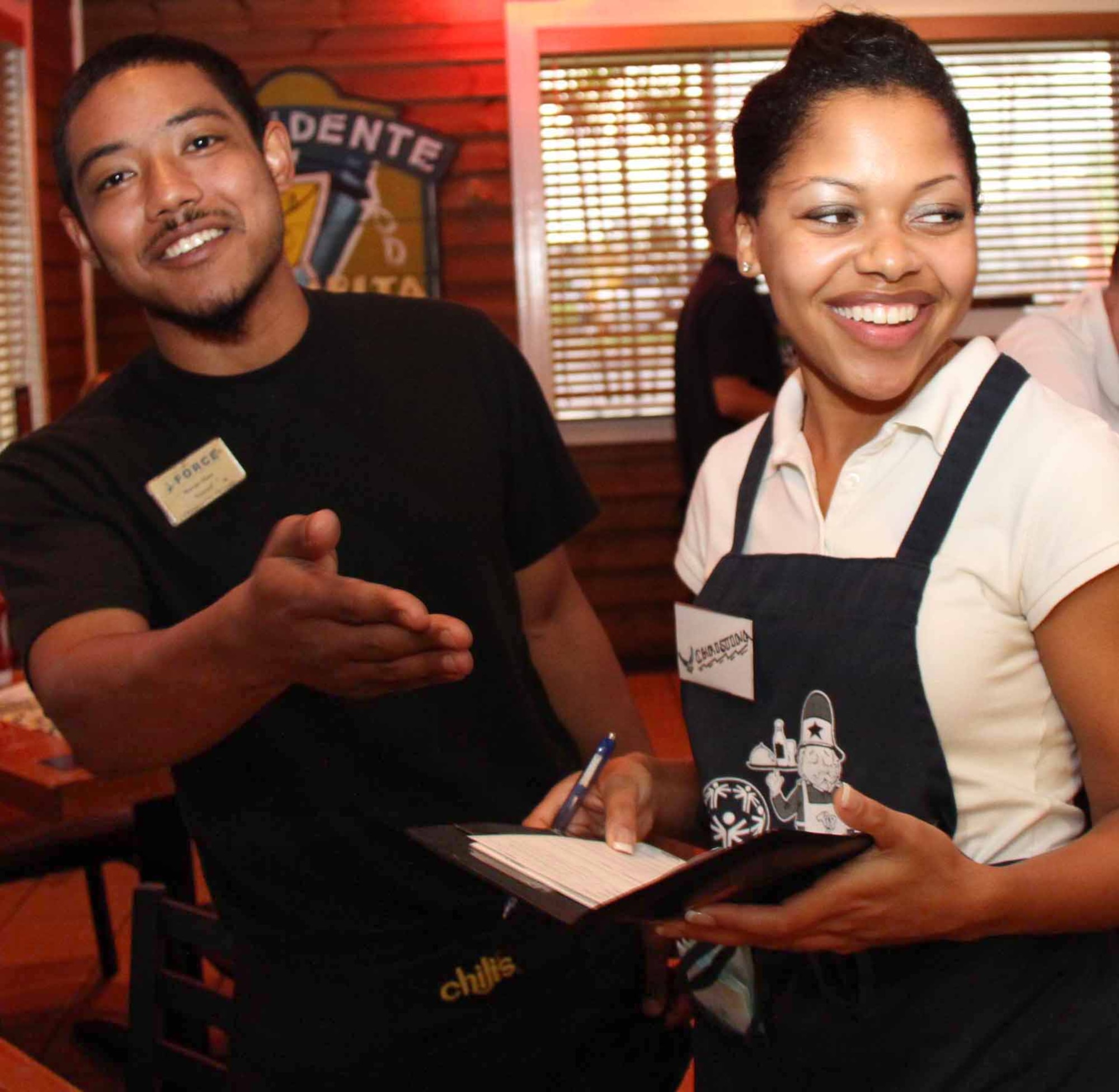 Chili's Waiter Marcus Maze and U.S. Air Force Special Agent Christina Royal serve patrons during the 2011 Kadena Special Olympics "Tip-A-Cop" event, Oct. 14. Volunteers raised more than $2,500 in support of the Special Olympics, which takes place Nov. 4 at Kadena Air Base. (U.S. Army photo/Chip Steitz)