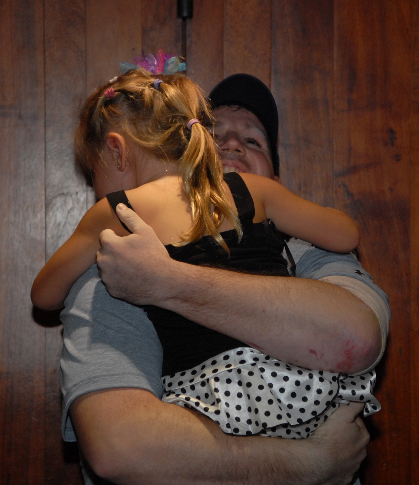 Staff Sgt. DJ Dutton greets his daughter, Madison, who will be 4 years old tomorrow, at the Honolulu International Airport Oct. 16 upon his return from a deployment to Afghanistan. Dutton, an explosive ordnance disposal technician deployed from the 647th Civil Engineer Squadron at Joint Base Pearl Harbor-Hickam, Hawaii, was wounded by an improvised explosive device Sept. 14 in Afghanistan. He was treated at Brooks Army Medical Center, Texas, before returning to his wife, Stacy (pictured), and two children. (U.S. Air Force photo by Staff Sgt. Carolyn Herrick)