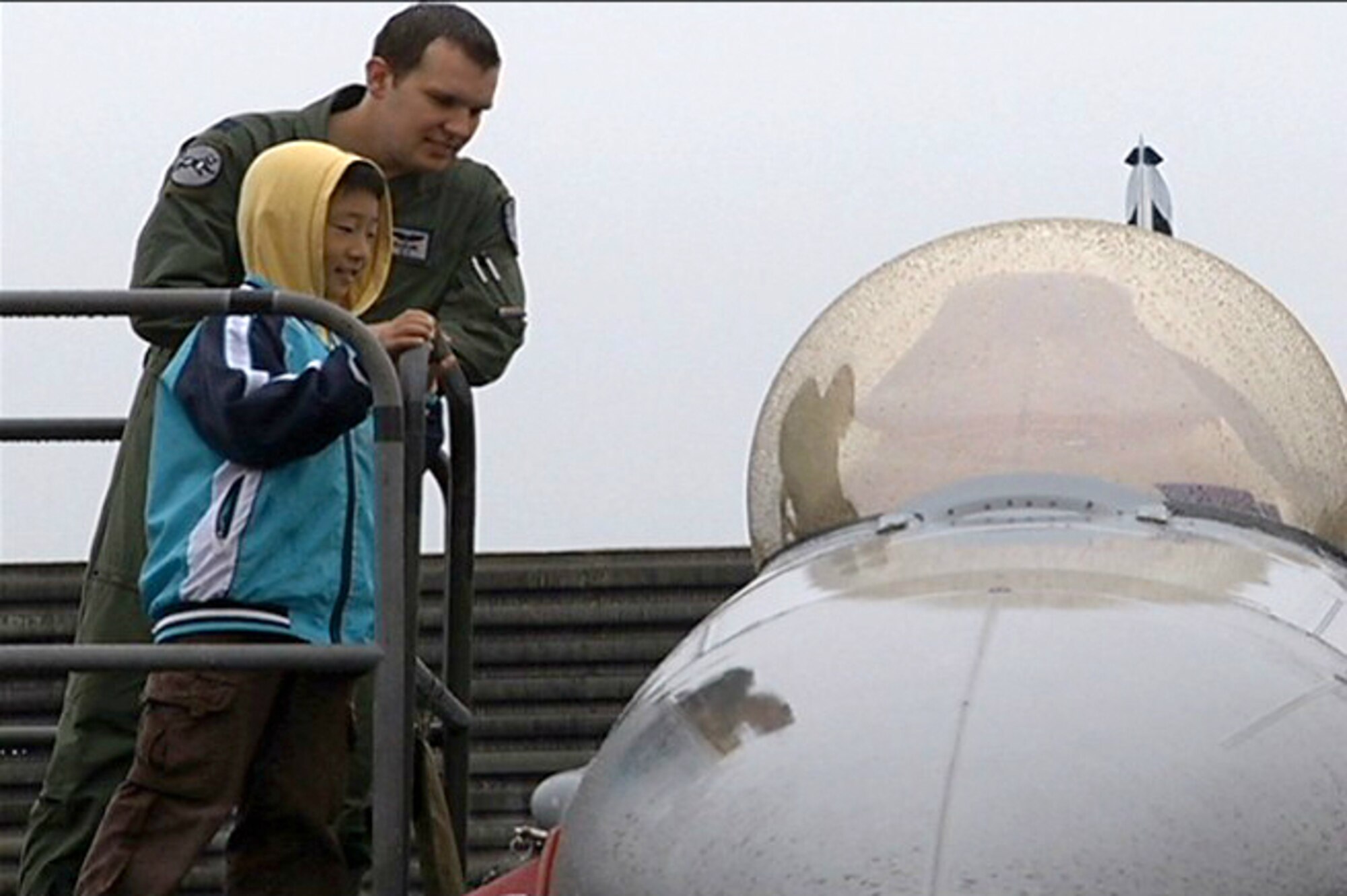 A pilot from the 35th Fighter Squadron shows a Korean student of Sinsido Elementary School from an island near Gunsan City the cockpit of an F-16 Fighting Falcon during a tour at Kunsan Air Base, Republic of Korea, Oct. 14, 2011. (U.S. Army photo by Spc. Christopher Wellner/Released)