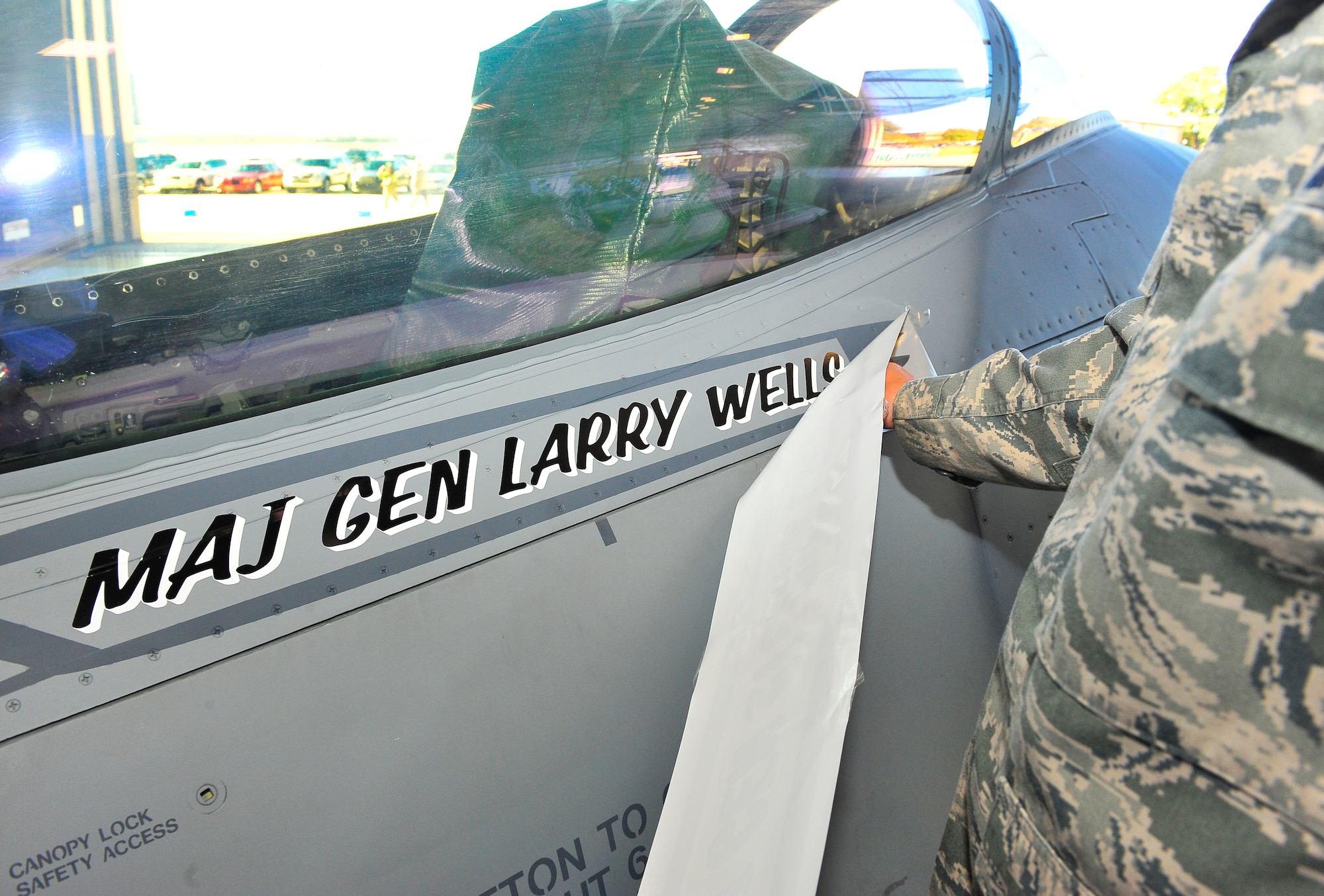 U.S. Air Force Maj. Gen. Lawrence Wells, 9th Air Force commander, name is revealed on an F-16 fighter jet after taking command, Oct. 17, 2011, Shaw Air Force Base, S.C. The 9th Air Force comprises seven wings and two direct reporting units in the eastern United States with more than 350 aircraft, and 24,000 active duty and civilian personnel. (U.S. Air Force photo by Airman 1st Class Neil D. Warner/Released)