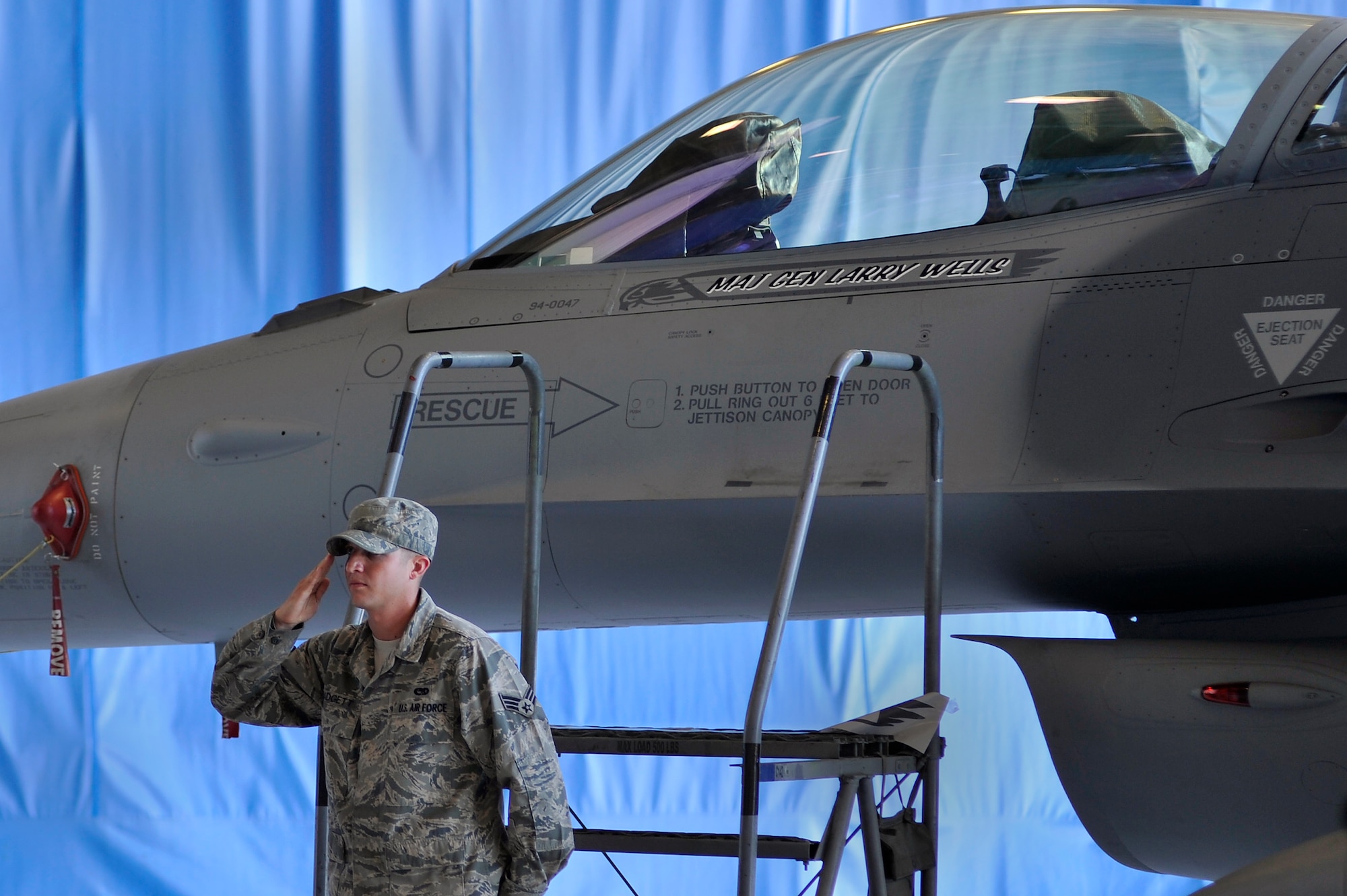 U.S. Air Force Senior Airman Kyle Padgett, 20th Aircraft Maintenance Squadron crew chief, renders a salute to Maj. Gen. Lawrence Wells, 9th Air Force commander, after unveiling the general's name displayed on the F-16 Fighting Falcon behind Padgett during the 9th Air Force Change of Command, Oct. 17, 2011. Shaw Air Force Base, S.C. During the ceremony Maj. Gen. Stephen Hoog relinquished command to Maj. Gen. Lawrence Wells.  The 9th Air Force is comprises seven wings and two direct reporting units in the eastern United States with more than 350 aircraft, and 24,000 active duty and civilian personnel. (U.S. Air Force photo by Senior Airman Kenny Holston/Released)


