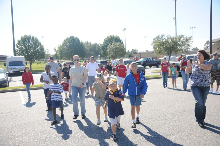 Families participating in the Kids Deployment Line march and sing cadence as they transition from the K-9 demonstration to the bouncy houses at Moody Air Force Base Ga., Oct. 15, 2011. The children were put into four groups led by Team Moody volunteers, and each was assigned to a different station where they rotated every 30 minutes. (U.S. Air Force photo by Airman 1st Class Paul Francis/Released)
