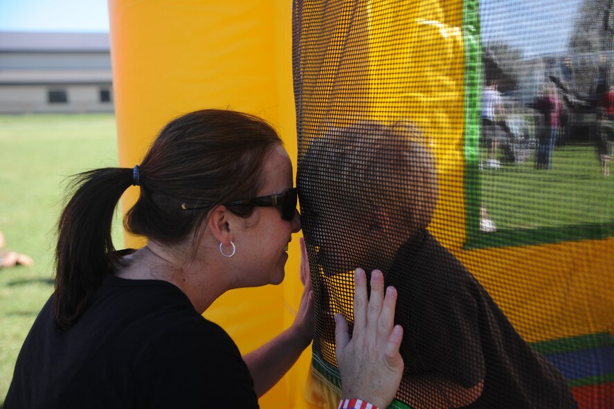 Kate and Cade Passey, dependents of U.S. Air Force 2nd Lt. Kendrick Passey, 38th Rescue Squadron, share a moment as Kylie plays in a bounce house at Moody Air Force Base, Ga., for the  Kids Deployment Line on Oct. 15, 2011. The deployment line is a way to help children understand and cope with their parent’s deployments. (U.S. Air Force photo by Airman 1st Class Paul Francis/Released)
