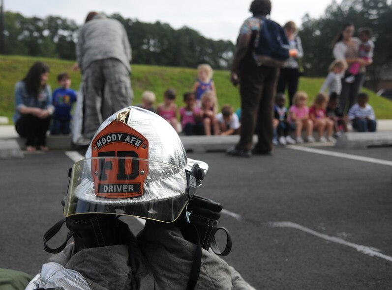 Members from the 23rd Civil Engineer Squadron fire department visit with children from the Child Development Center II Oct. 13, 2011, at Moody Air Force Base, Ga for National Fire Prevention Week. The fire department educated the children about fire safety and also gave them a tour of their fire truck. (U.S. Air Force photo by Airman 1st Class Paul Francis/Released)
