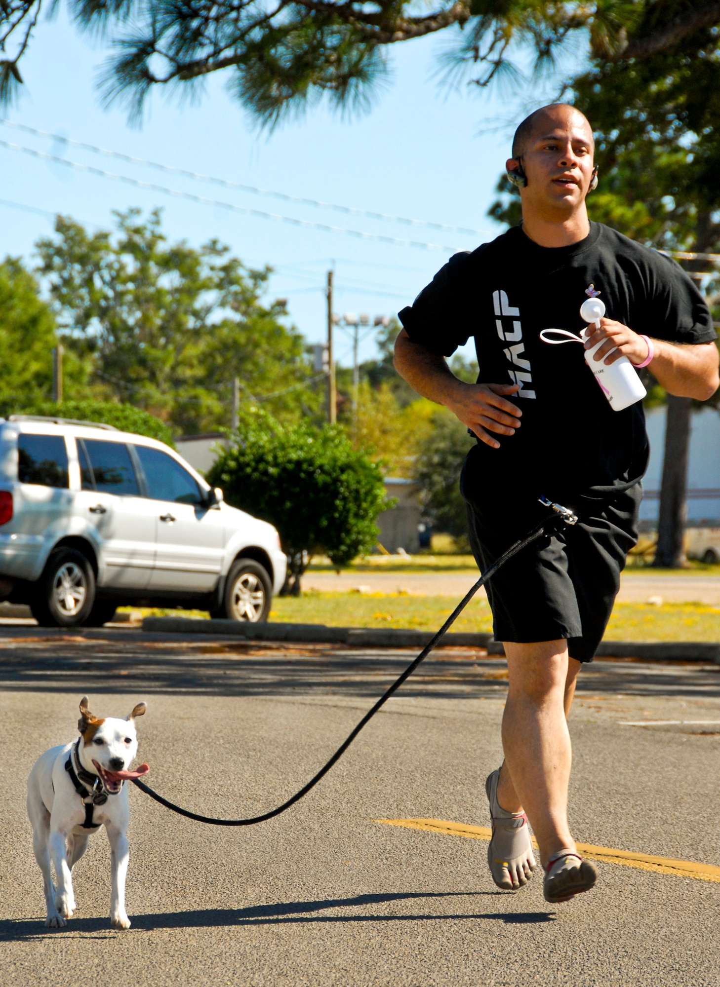 Staff Sgt. Maximus Moretta, of the 96th Logistics Readiness Squadron, and his dog Mambo, participate in the Breast Cancer 5K run/walk at Eglin Air Force Base Fla., Oct. 14. The event helps to raise awareness of the importance for women to self-test and catch the disease in its early stages. More than 100 people attended the event. (U.S. Air Force photo/Sachel Seabrook)