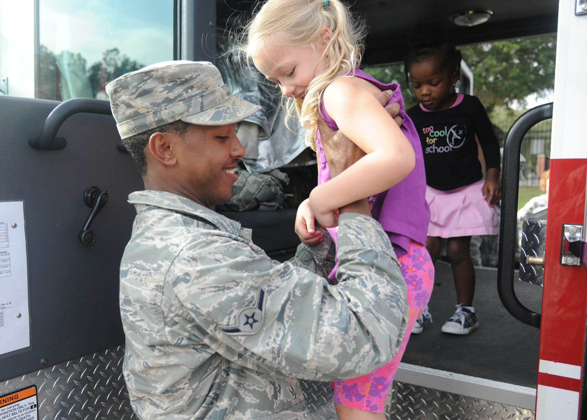U.S. Air Force Airman Joshua Davis, 23rd Civil Engineer Squadron firefighter, helps a child off a fire truck at Moody Air Force Base, Ga., Oct. 13, 2011 After the fire truck tour, 
Davis demonstrated to the kids how to properly equip and wear his firefighter gear. Davis and fellow firefighters educated children on fire safety as part of National Fire Safety week; a week that is dedicated to promoting fire safety and prevention.  (U.S. Air Force photo by Airman 1st Class Paul Francis/Released)
