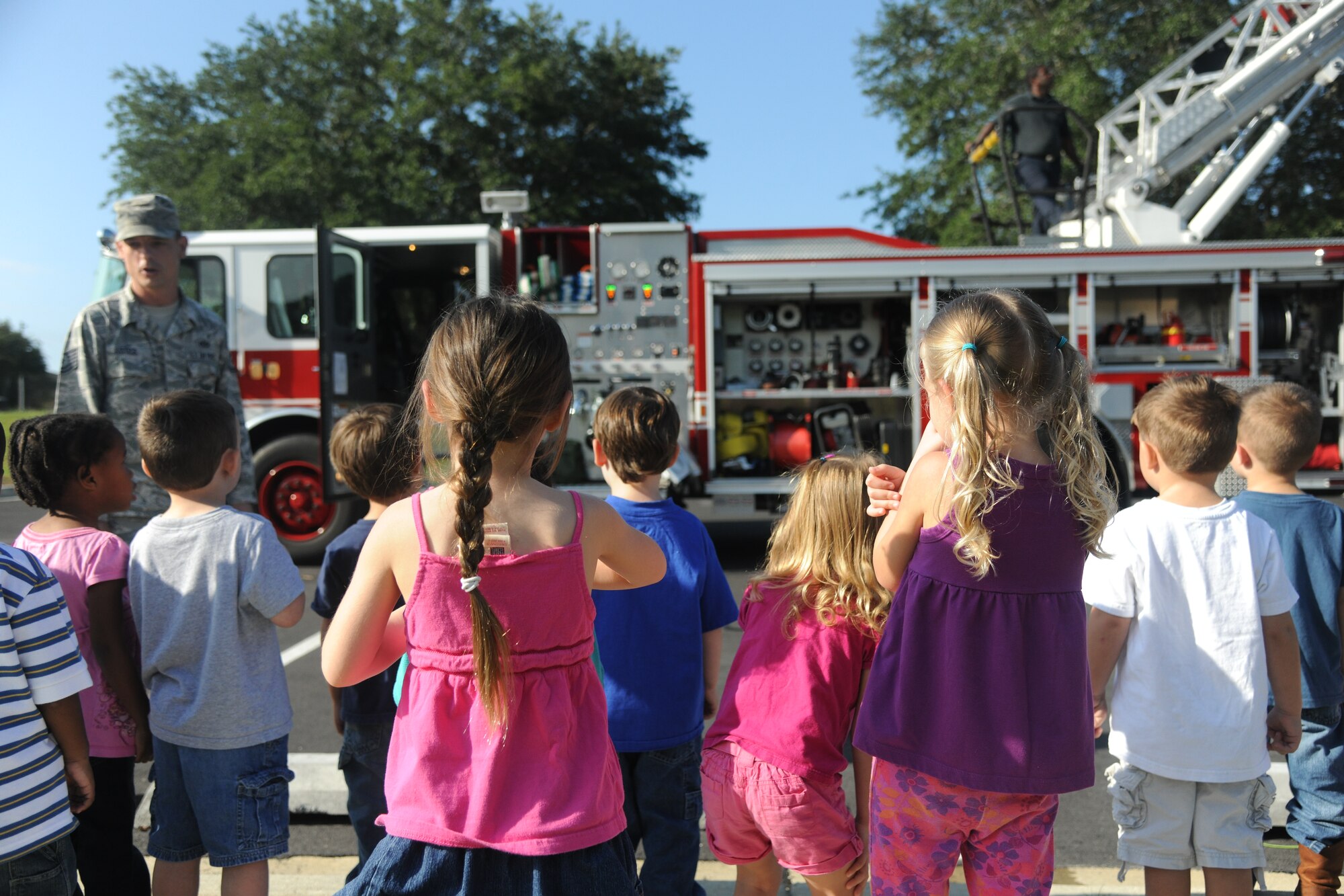 Children from the Child Development Center II at Moody Air Force Base, Ga., gather around U.S. Air Force Tech. Sgt. Alan Justice, 23rd Civil Engineer Squadron firefighter, Oct. 13, 2011, for National Fire Prevention Week. Justice explained to the children how the fire truck behind him operates and what it’s used for. (U.S. Air Force photo by Airman 1st Class Paul Francis/Released)
