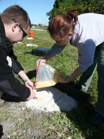 AFOSI agents pour plaster into a footprint during crime scene processing training. (U.S. Air Force photo)