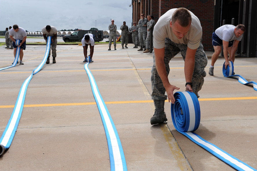 Airmen from the 23rd Logistics Readiness Squadron participate in the hose roll during a Fire Muster Challenge at Moody Air Force Base, Ga., Oct. 11, 2011. During the challenge, members had to completely unroll five hoses, re-roll them and stack them as quickly as possible. (U.S. Air Force photo by Senior Airman Ciara Wymbs/Released)