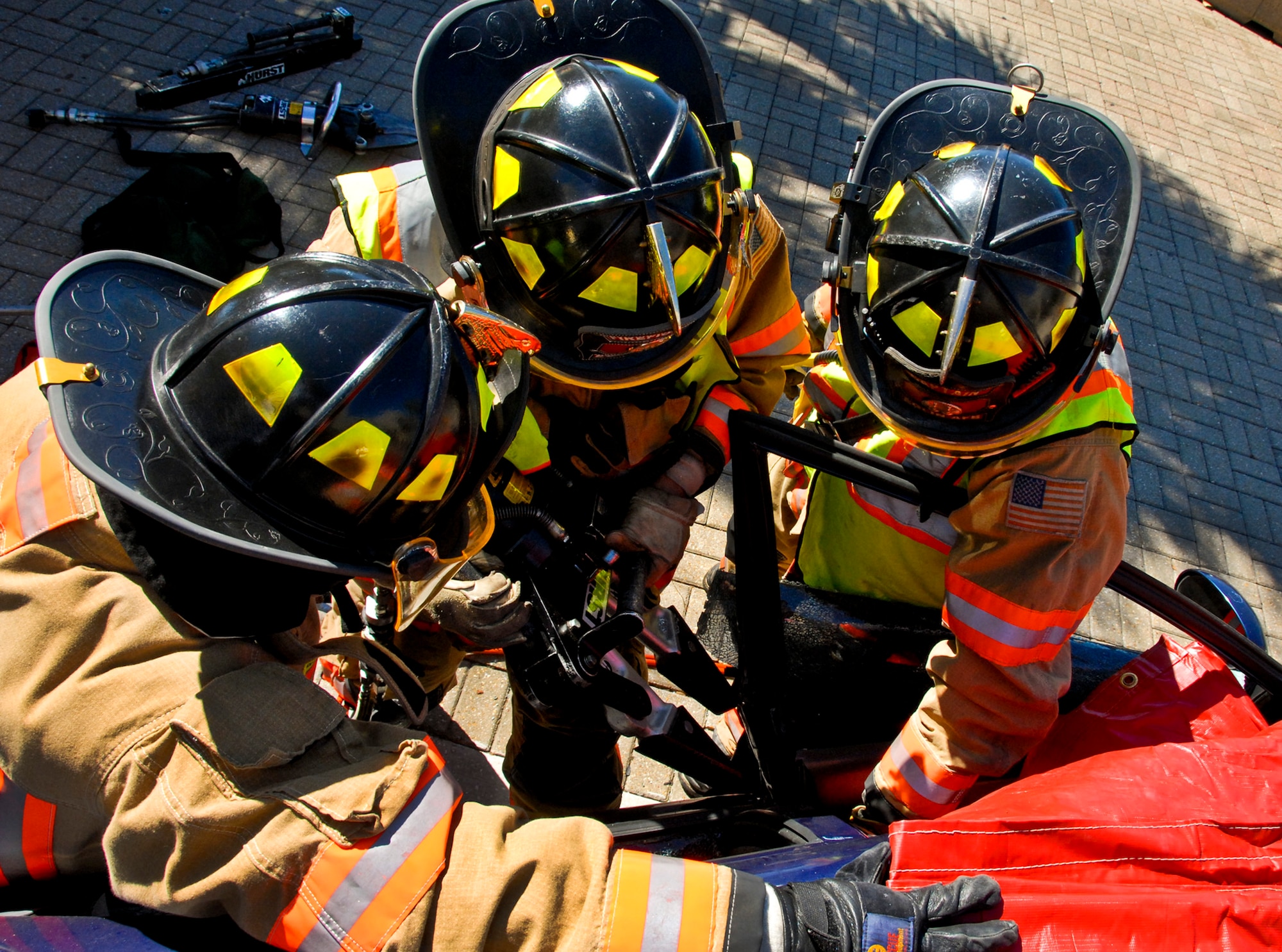 Firefighters from the 96th Civil Engineer Group use the ‘Jaws of Life’ to open a car door during a demonstration at the base exchange Oct. 14 at Eglin Air Force Base, Fla.  The demonstration simulated how firefighters rescue victims involved in an automobile crash as part of Fire Prevention Week.  (U.S. Air Force photo/Kevin Gaddie)