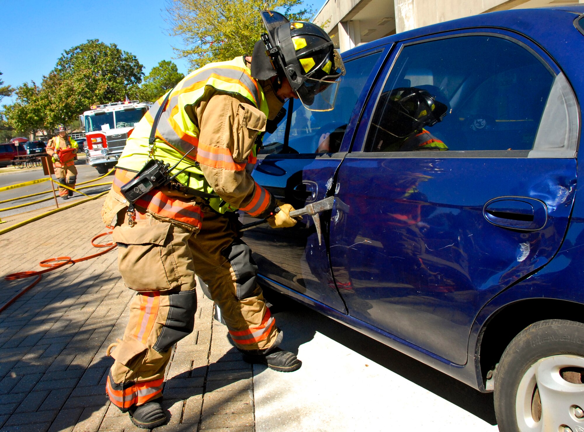 A firefighter from the 96th Civil Engineer Group pries open a car door during a ‘Jaws of Life’ demonstration at the base exchange Oct. 14 at Eglin Air Force Base, Fla.  The demonstration simulated how firefighters rescue victims involved in an automobile crash as part of Fire Prevention Week.  (U.S. Air Force photo/Kevin Gaddie)
