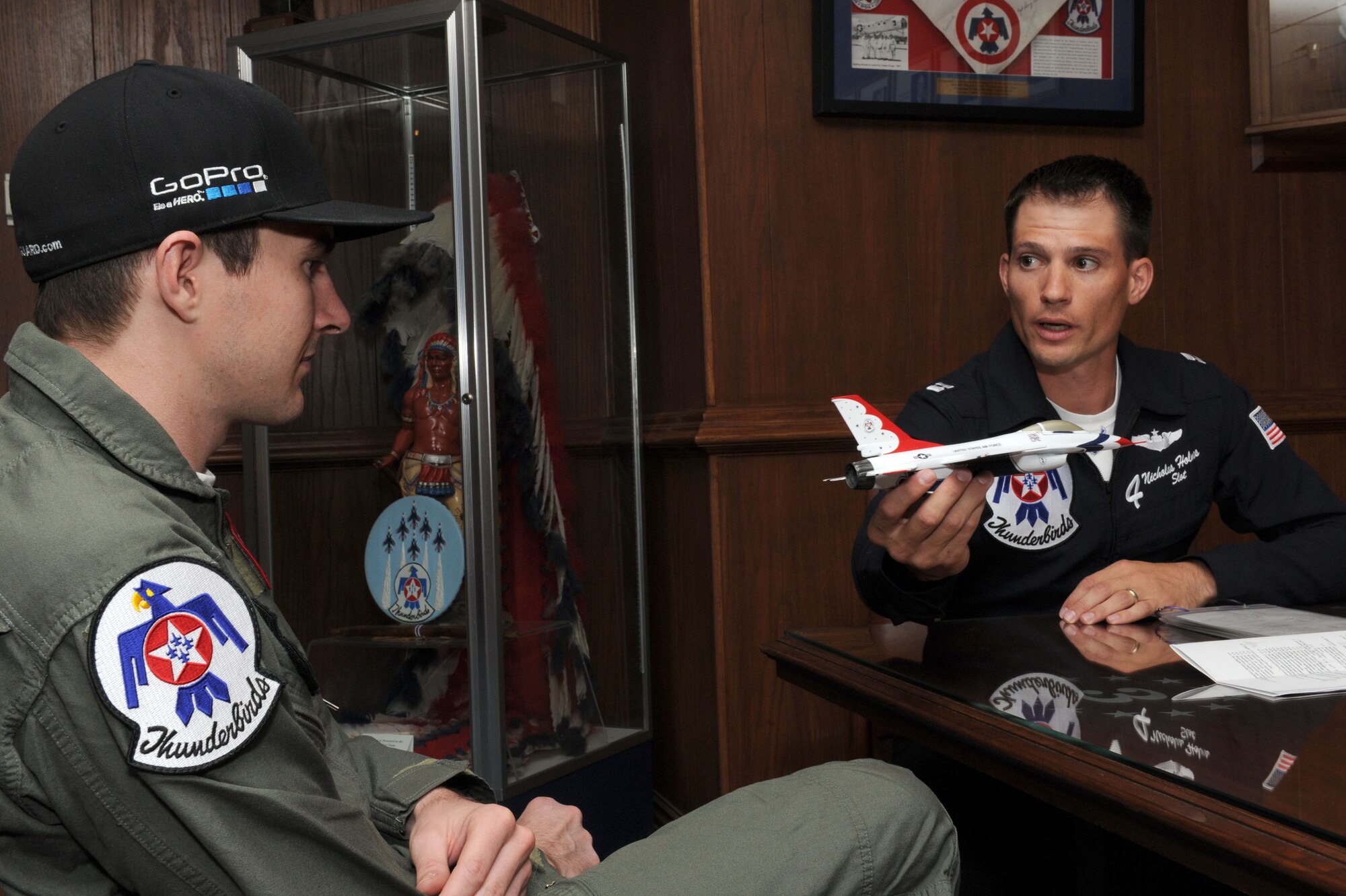 Capt. Nicholas Holmes, Thunderbird 4 slot pilot, demonstrates some of the profile manuevers to JR Hildebrand, IndyCar driver, before his Thunderbird F-16 Fighting Falcon flight Oct. 11, 2011, at Nellis Air Force Base, Nev. Hildebrand, driver of the number four National Guard car for Panther Racing, came to Las Vegas to compete in the IZOD IndyCar World Championship at the Las Vegas Motor Speedway. (U.S. Air Force photo by Staff Sgt. Larry E. Reid Jr./Released)