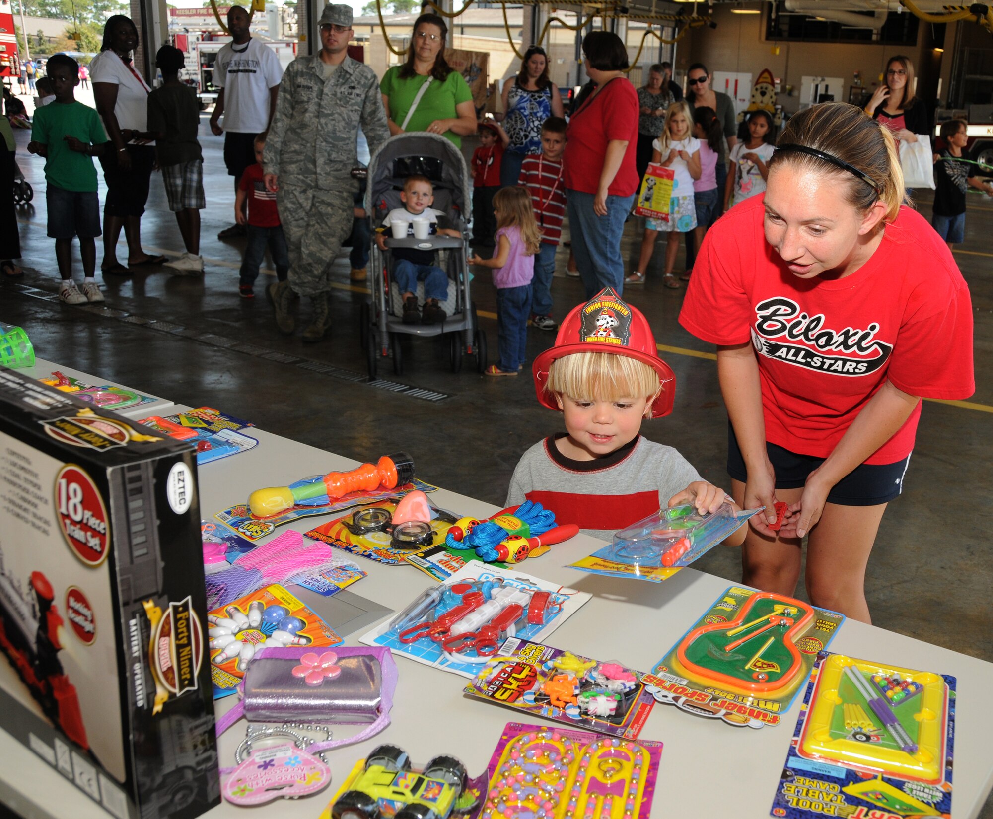 Caleb Cloninger, 3, and his mom Kelly,dependants of Master Sgt. David Cloninger, 336th Training Squadron, choose a door prize during the Keesler Fire Department open house Oct. 15, 2011, Keesler Air Force Base, Miss.  The event was the finale to Fire Prevention Week held Oct. 11-15, 2011. (U.S. Air Force photo by Kemberly Groue)