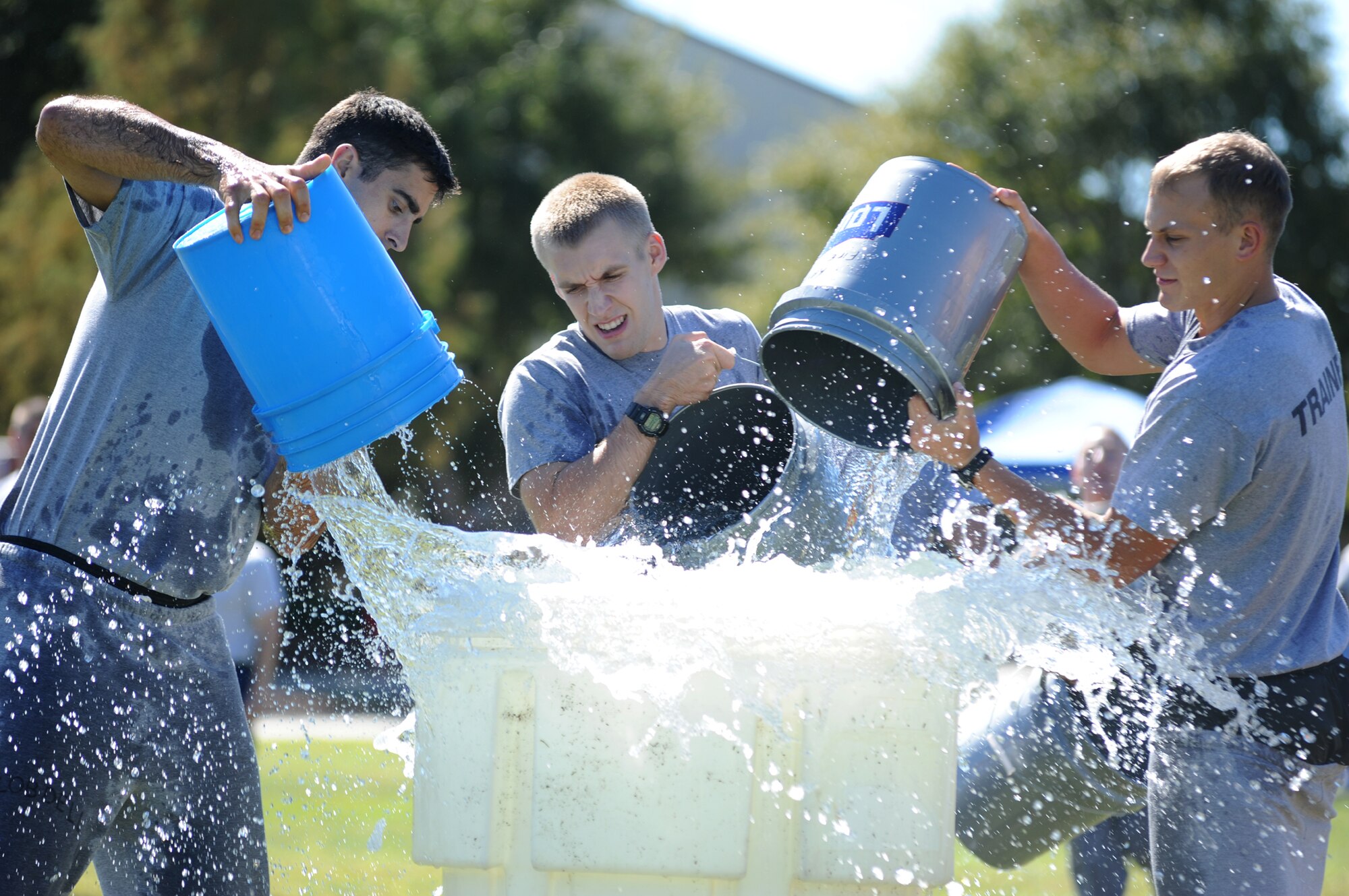 Left, Airmen 1st Class Joe Robdell, Michael Shipley, and Zane Gaiser, 335th Training Squadron students, participate in the “Bucket Brigade” competition at the Fire Muster, Oct. 14, 2011, Keesler Air Force Base, Miss.  The Fire Muster is sponsored by the Keesler Fire Department which runs in conjunction with Fire Prevention Week Oct. 11-15, 2011.  (U.S. Air Force photo by Kemberly Groue)