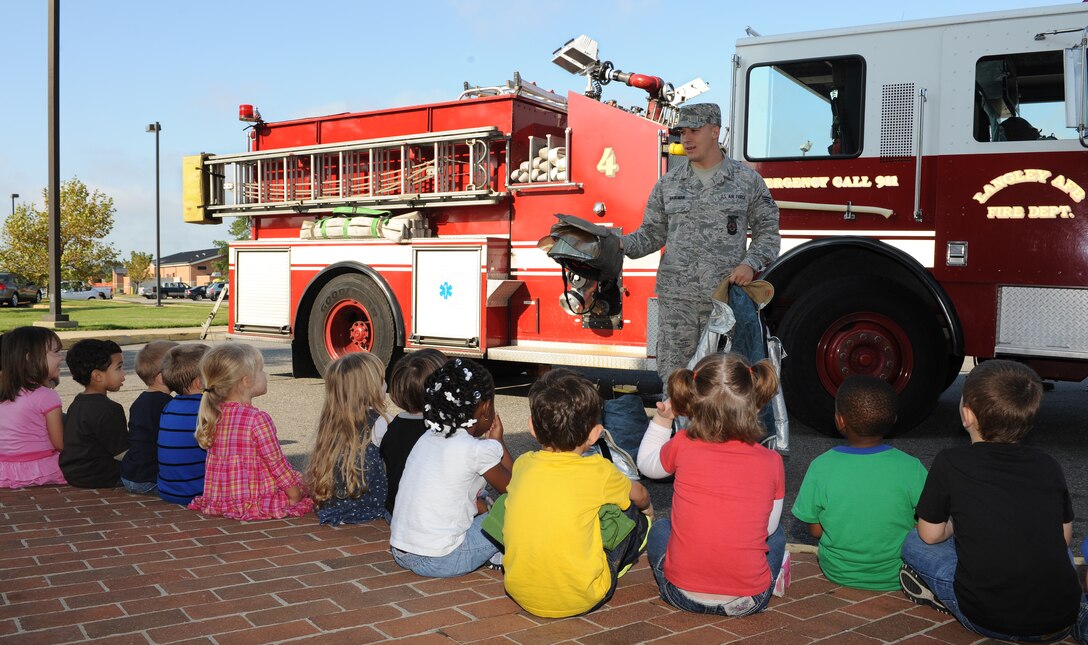 U.S. Air Force Senior Airman Thomas Haulmann, 633rd Civil Engineer Squadron firefighter, demonstrates the protective gear firefighters wear when responding to fires at Langley Air Force Base, Va., Oct. 13, 2011. Base firefighters taught children at the child development center about fire safety during National Fire Prevention week, Oct. 10-14. (U.S. Air Force photo by Airman 1st Class Teresa Cleveland/Released)