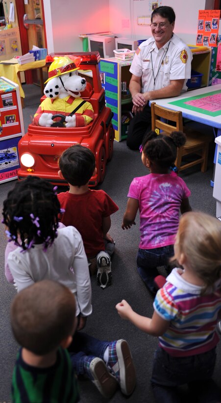 Sparky Jr. and Rick Pettyjohn, 633rd Civil Engineer Squadron assistant chief of fire prevention, talk to children about fire safety during National Fire Prevention Week at Langley Air Force Base, Va., Oct. 13,2011. Firefighters offered demonstrations and educational events throughout the week promoting fire safety and prevention. (U.S. Air Force photo by Airman 1st Class Teresa Cleveland/Released)