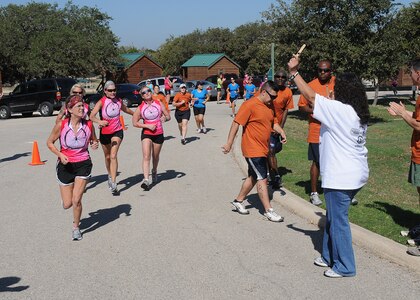 Martha Arizpe, right,  hands out finish numbers to runners competing in Rambler 120 at Canyon Lake, Texas. The event, hosted by Joint Base San Antonio,  included running, cyling and rowing and was concluded with a picnic. Arizpe is with the 502nd Air Base Wing, Information Protection, at Randolph Air Force Base, Texas.  (U.S. Air Force photo/Dave Terry)