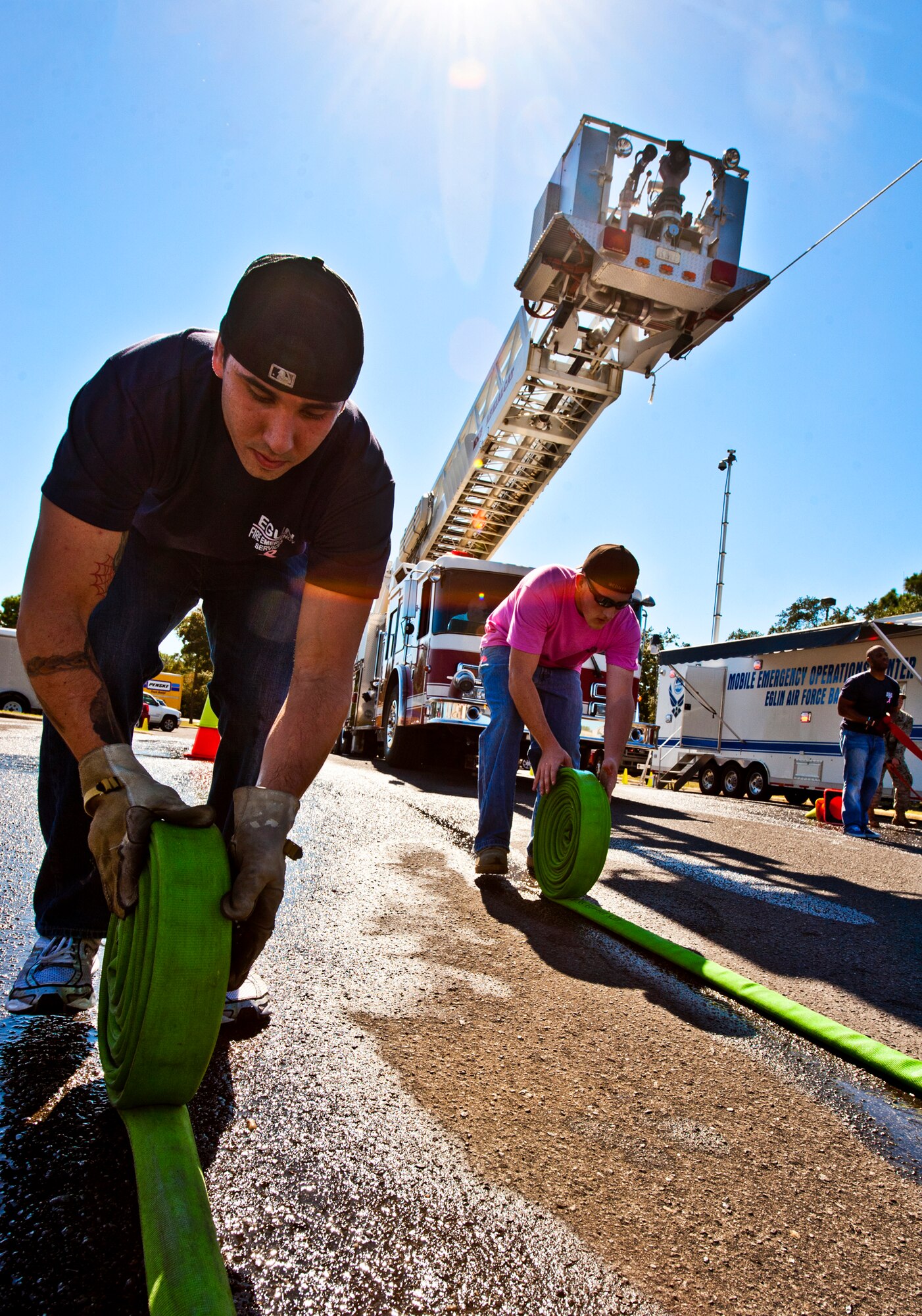 Members of the base fire department quickly roll up hoses for the next round of competition during the Fire Muster Challenge competition Oct. 14 at Eglin Air Force Base, Fla.  The competition concluded Eglin fire department's Fire Prevention Week campaign.  (U.S. Air Force photo/Samuel King Jr.)
