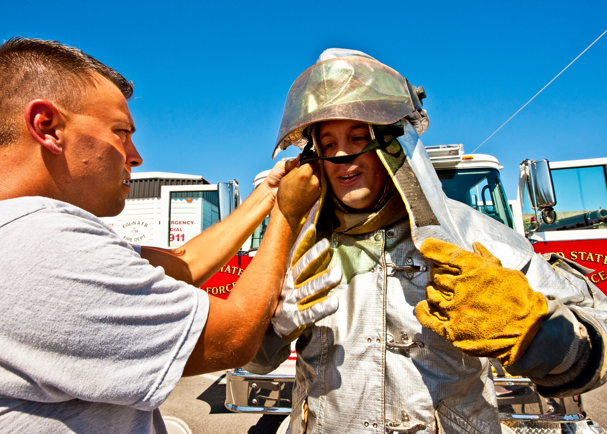 The Combat Shield team member makes sure his partner wears the fire suit properly during the first phase of this year's Fire Muster Challenge competition Oct. 14 at Eglin Air Force Base, Fla.  The competition concluded Eglin fire department's Fire Prevention Week campaign.  (U.S. Air Force photo/Samuel King Jr.)
