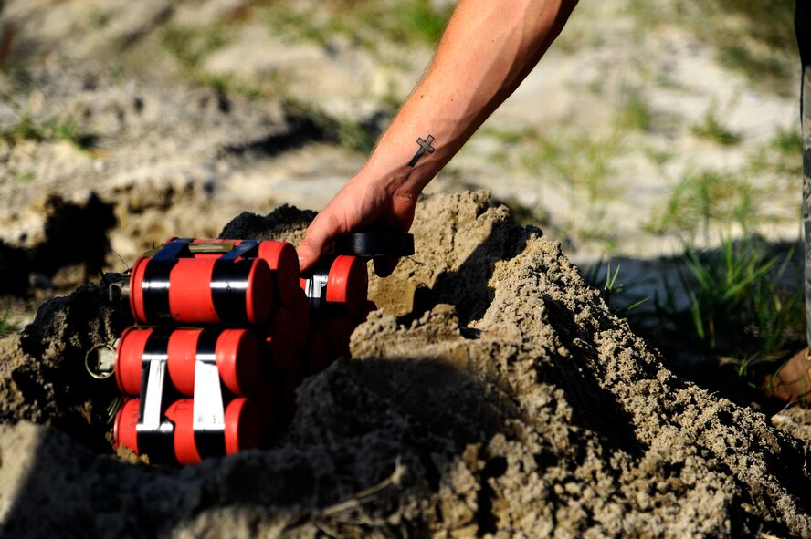U.S. Air Force Airman 1st Class Thomas Johnson, an explosive ordinance disposal apprentice from 1st Special Operations Civil Engineer Squadron, places a nest of thermite charges on the range at Hurlburt Field, Fla., Sept. 27, 2011.  Most types of thermite are not explosive, but can create bursts of extremely high temperatures focused in a very small area for a short period of time. (U.S. Air Force photo/Airman Gustavo Castillo)(Released)
