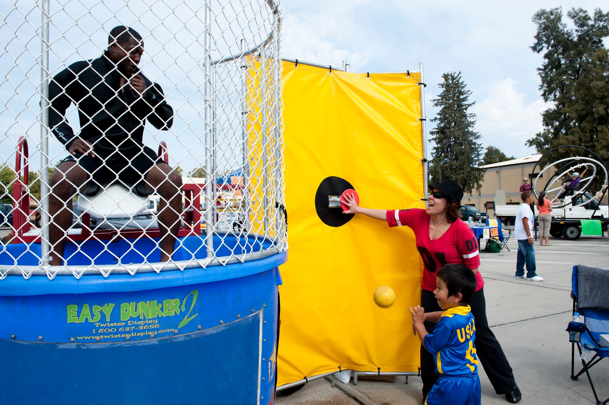 A child receives help at the dunk booth during the annual Fall Fest Oct. 15, 2011, at Incirlik Air Base, Turkey. The event is hosted by the 39th Force Support Squadron and includes a variety of food, activities and base organization booths. (U.S. Air Force photo by Senior Airman Anthony Sanchelli/Released)