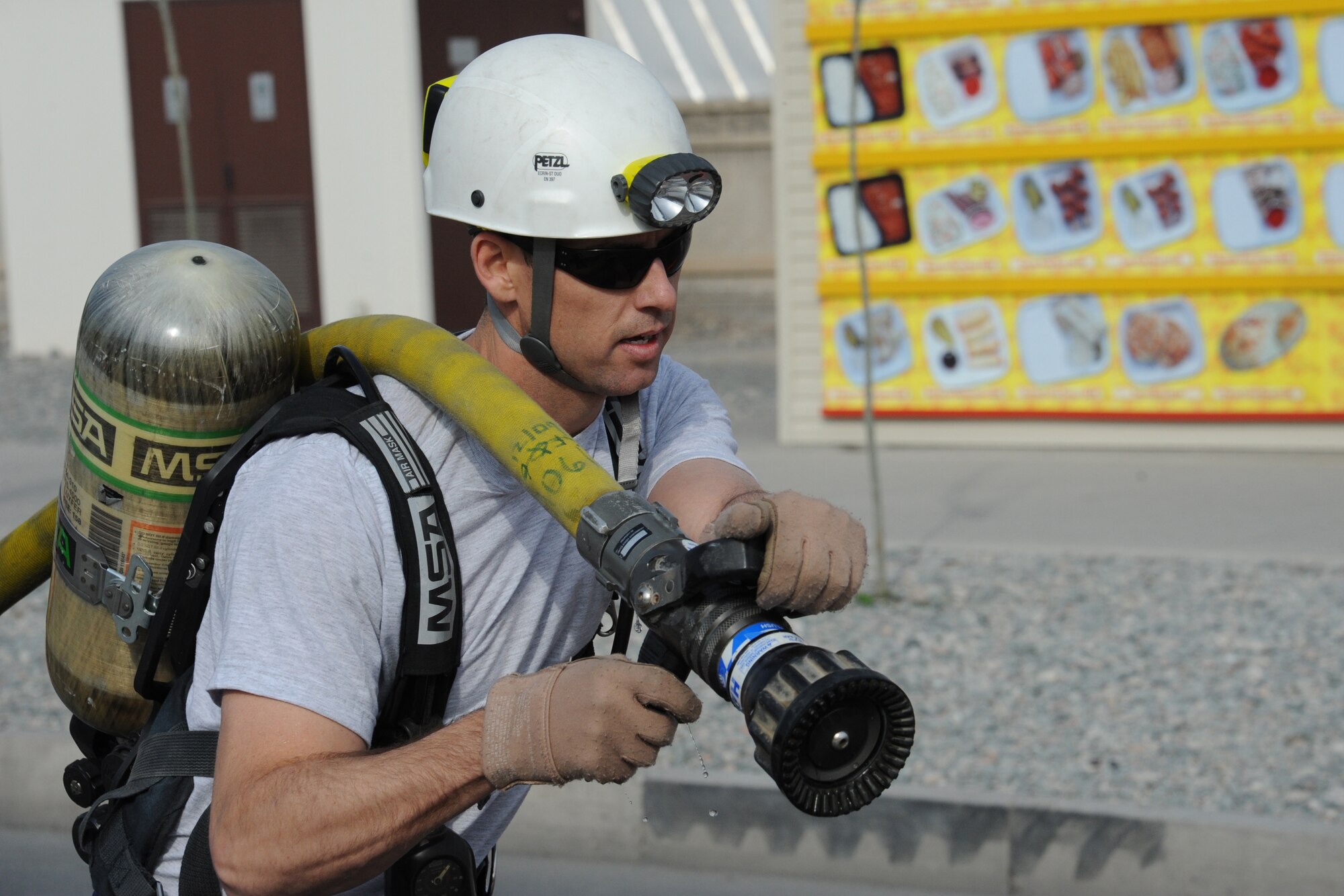 Tech. Sgt. Randy Stinnett prepares to open the valve on a charged fire-hose Oct. 15 during the 2011 Firefighter Challenge at the Transit Center at Manas, Kyrgyzstan. Five teams participated in the event where each member of every team had to complete a series of timed challenges, such as a fire extinguisher swap-out, fire-hose carry, dummy lift and carry, and precision fire-hose shooting. The challenge was the capstone event during this year's Fire Prevention Week here. Stinnett is a 22nd Expeditionary Air Refueling Squadron boom operator deployed here from Fairchild Air Force Base, Wash. He is a native of Laverne, Okla. (U.S. Air Force photo/Maj. Bob Everdeen)