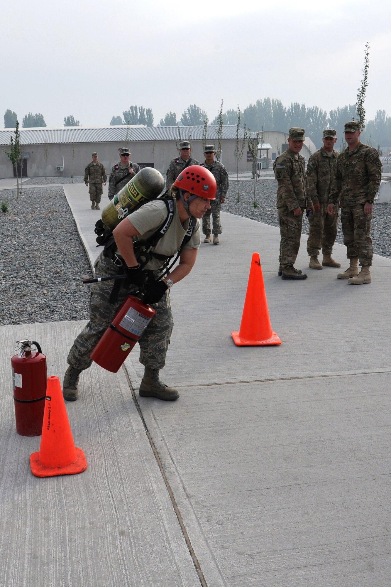 Tech. Sgt. Jennifer Toft of the 376th Expeditionary Civil Engineer Squadron moves quickly through the fire extinguisher swap-out station during the 2011 Firefighter Challenge Oct. 15 at the Transit Center at Manas. The station was one of several designed to test participants' strength and skill in various areas of the challenge course. Toft was part of the winning team--"Team Thundercat"--from the 376th ECES. Toft a native of Elizabethton, Tenn, is deployed from Ramstein Air Base, Germany. (U.S. Air Force photo/Maj. Bob Everdeen)
