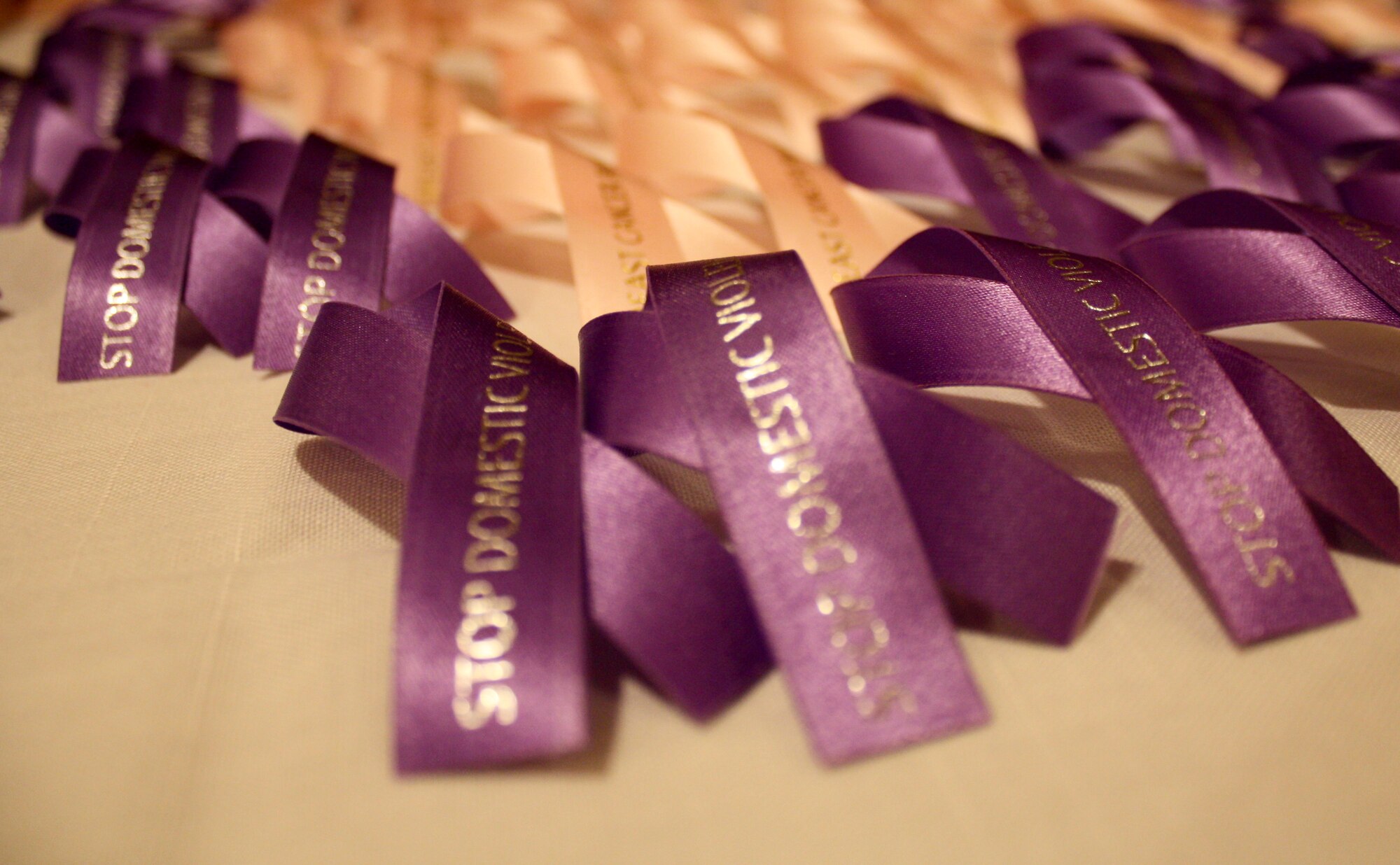 Guests wear either pink or purple ribbons to express their unity of support towards breast cancer and domestic abuse awareness during the Pink Dress and Purple Tie Gala at the Rocker NCO Club on Kadena Air Base, Japan, Oct. 7. Guests were encouraged to wear pink dresses and purple ties to support those who have struggled with breast cancer and domestic abuse. (U.S. Air Force photo/2nd Lt. Hope Cronin/Released)