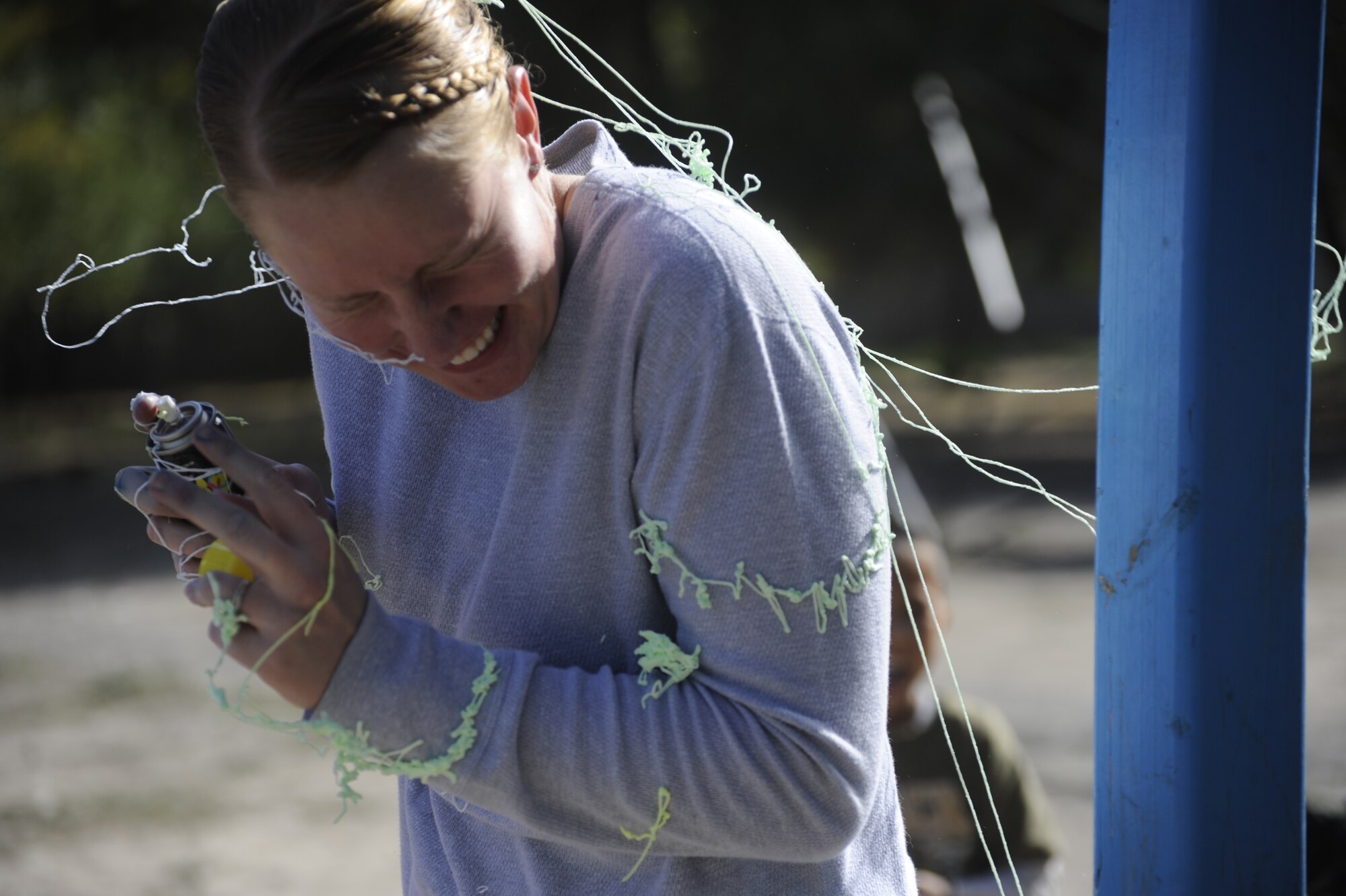 Staff Sgt. Tina Talamantes tries to dodge silly string spray at the Nizhanchuisk Orphanage and School, Kyrgyzstan, Oct. 13. Talamantes was one of six Manas Area Benefit Outreach Society Airmen who visited the orphanage to paint, deliver donations and play with the children. The society provides charitable donations, goods and services to people and organizations in the areas surrounding the Transit Center at Manas. Talamantes is a 376th Expeditionary Security Forces Squadron patrolman and is the Nizhanchuisk Orphanage alternate focus group leader for MABOS. The native of Steeleville, Ill., is deployed to the Transit Center from MacDill Air Force Base, Fla. (U.S. Air Force photo/Tech. Sgt. Tammie Moore)