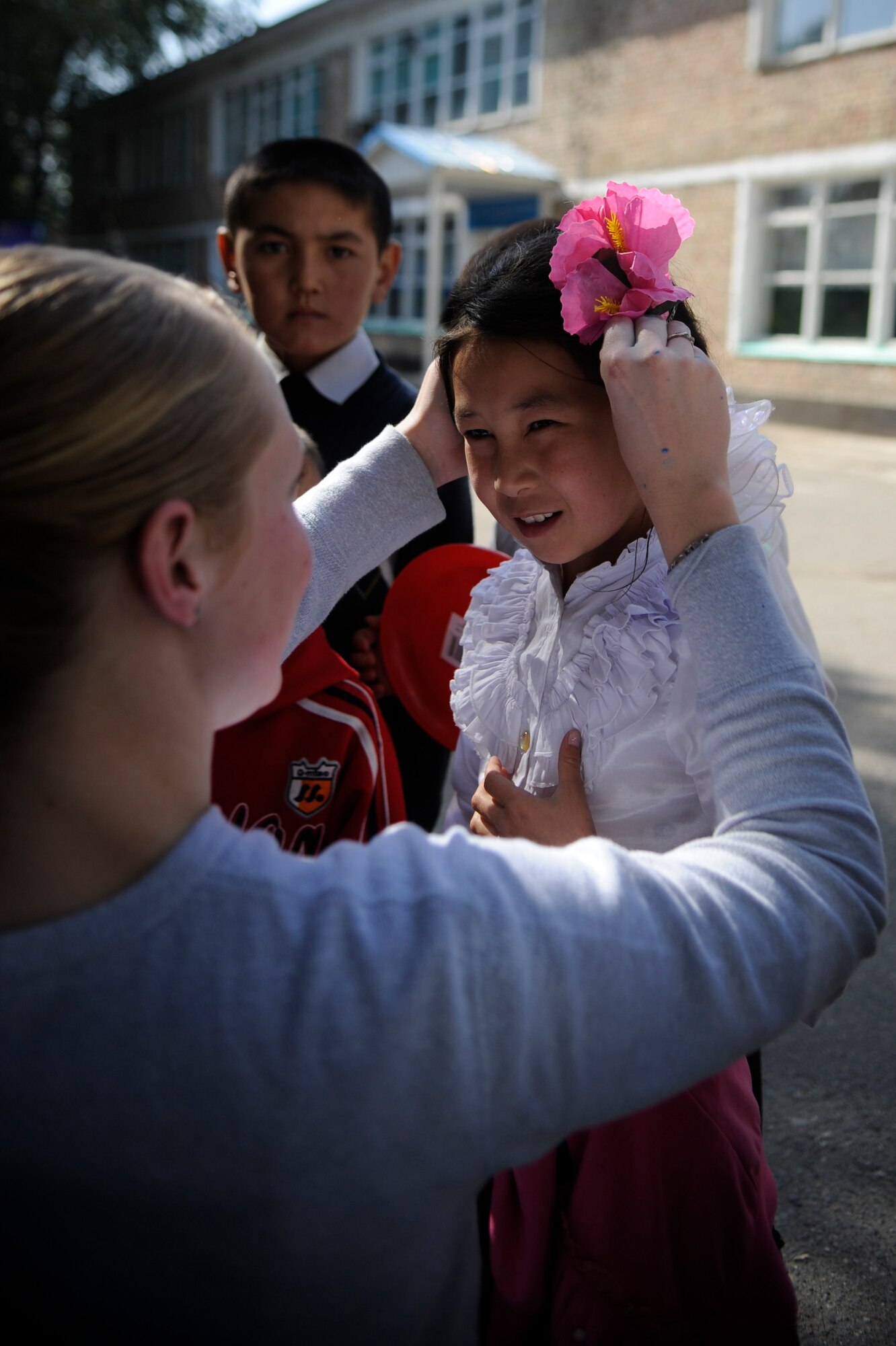 Staff Sgt. Tina Talamantes clips a flower hairclip in a girl’s hair at the Nizhanchuisk Orphanage and School, Kyrgyzstan, Oct. 13. Talamantes was one of six Manas Area Benefit Outreach Society Airmen who visited the orphanage to paint, deliver donations and play with the children. The society provides charitable donations, goods and services to people and organizations in the areas surrounding the Transit Center at Manas. Talamantes is a 376th Expeditionary Security Forces Squadron patrolman and is the MABOS Nizhanchuisk Orphanage alternate focus group leader. The native of Steeleville, Ill., is deployed to the Transit Center from MacDill Air Force Base, Fla. (U.S. Air Force photo/Tech. Sgt. Tammie Moore)