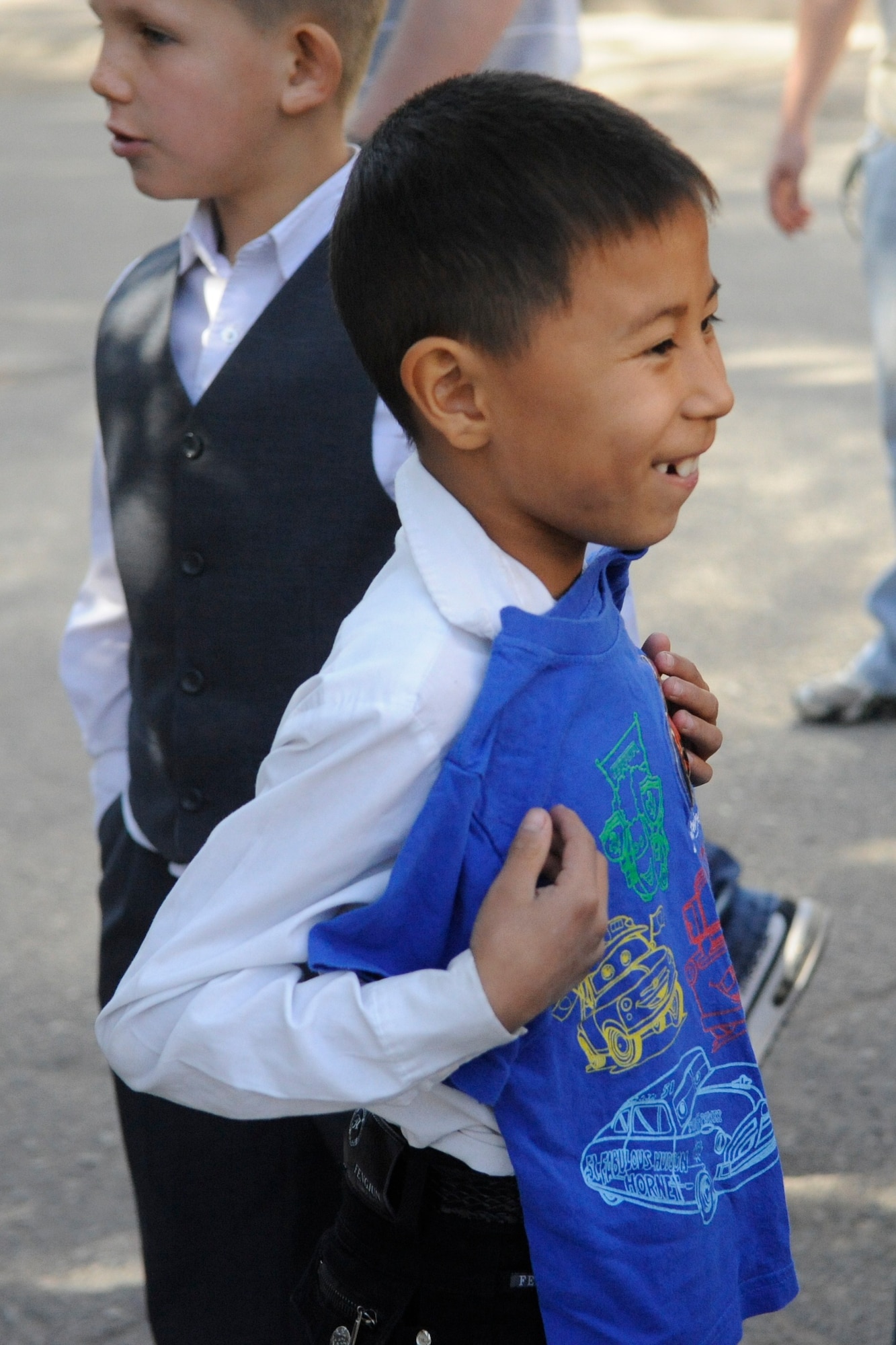 A boy smiles with joy after receiving a T-shirt donated by members of the Manas Area Benefit Outreach Society at the Nizhanchuisk Orphanage and School, Kyrgyzstan, Oct. 13. MABOS is a private organization at the Transit Center at Manas dedicated to improving the lives of Kyrgyz people through various local charities, orphanages and hospitals. Members of MABOS visit the school about twice a month to assist with projects and deliver supplies. (U.S. Air Force photo/Tech. Sgt. Tammie Moore)