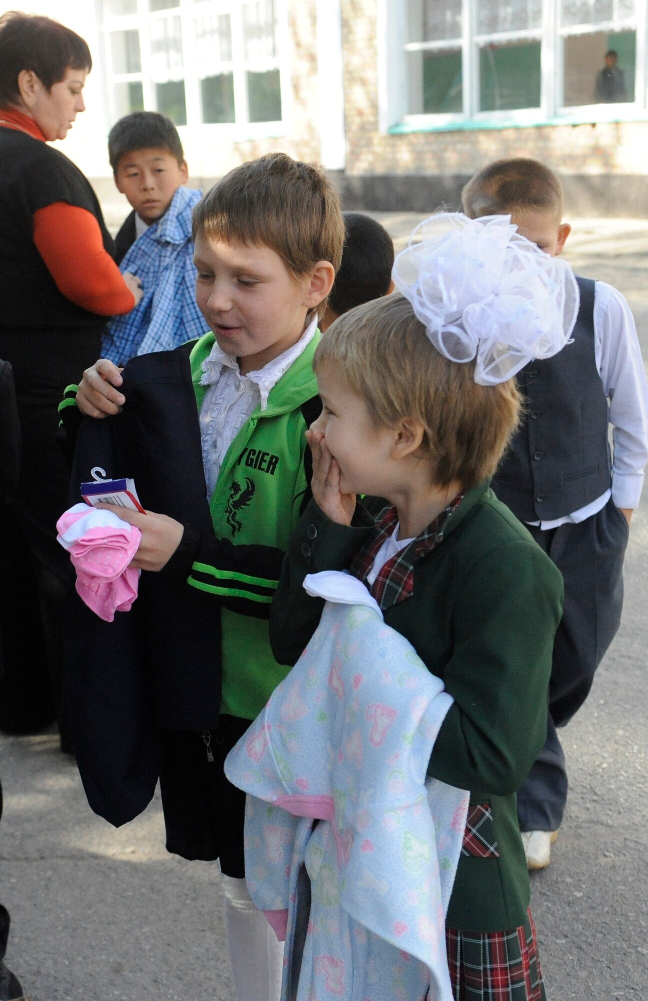 Children happily accept donated clothing from members of the Manas Area Benefit Outreach Society at the Nizhanchuisk Orphanage and School, Kyrgyzstan, Oct. 13. MABOS is a private organzation at the Transit Center at Manas dedicated to improving the lives of Kyrgyz people through various local charities, orphanages and hospitals. Members of MABOS visit the school about twice a month to assist with projects and deliver supplies. (U.S. Air Force photo/Tech. Sgt. Tammie Moore)